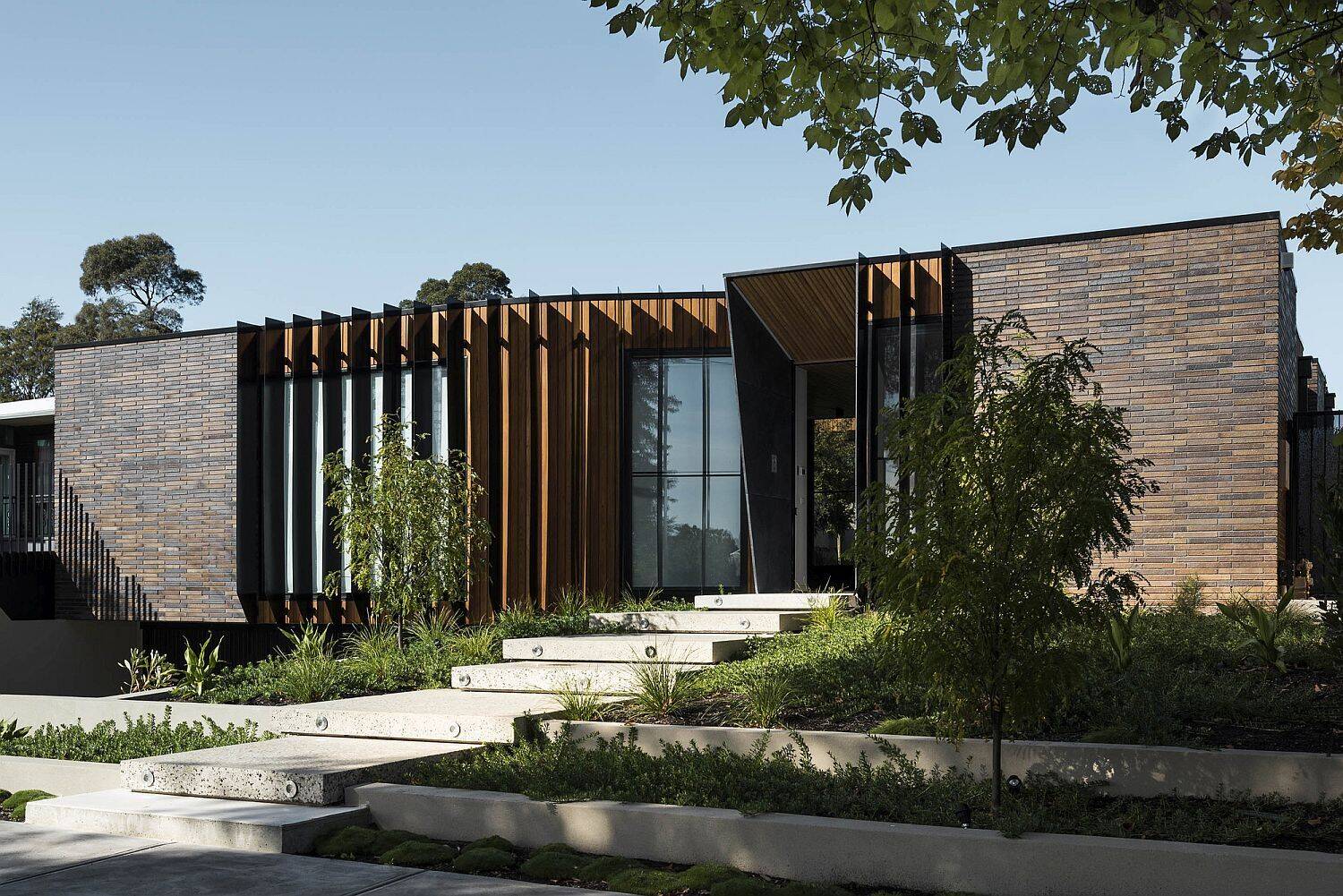 At first glance, the elongated brown brick defines the home’s character. This material, chosen for its ties to the working-class history of the area, wraps the exterior and continues inside, creating rhythm and texture in unexpected places like the entryway. 