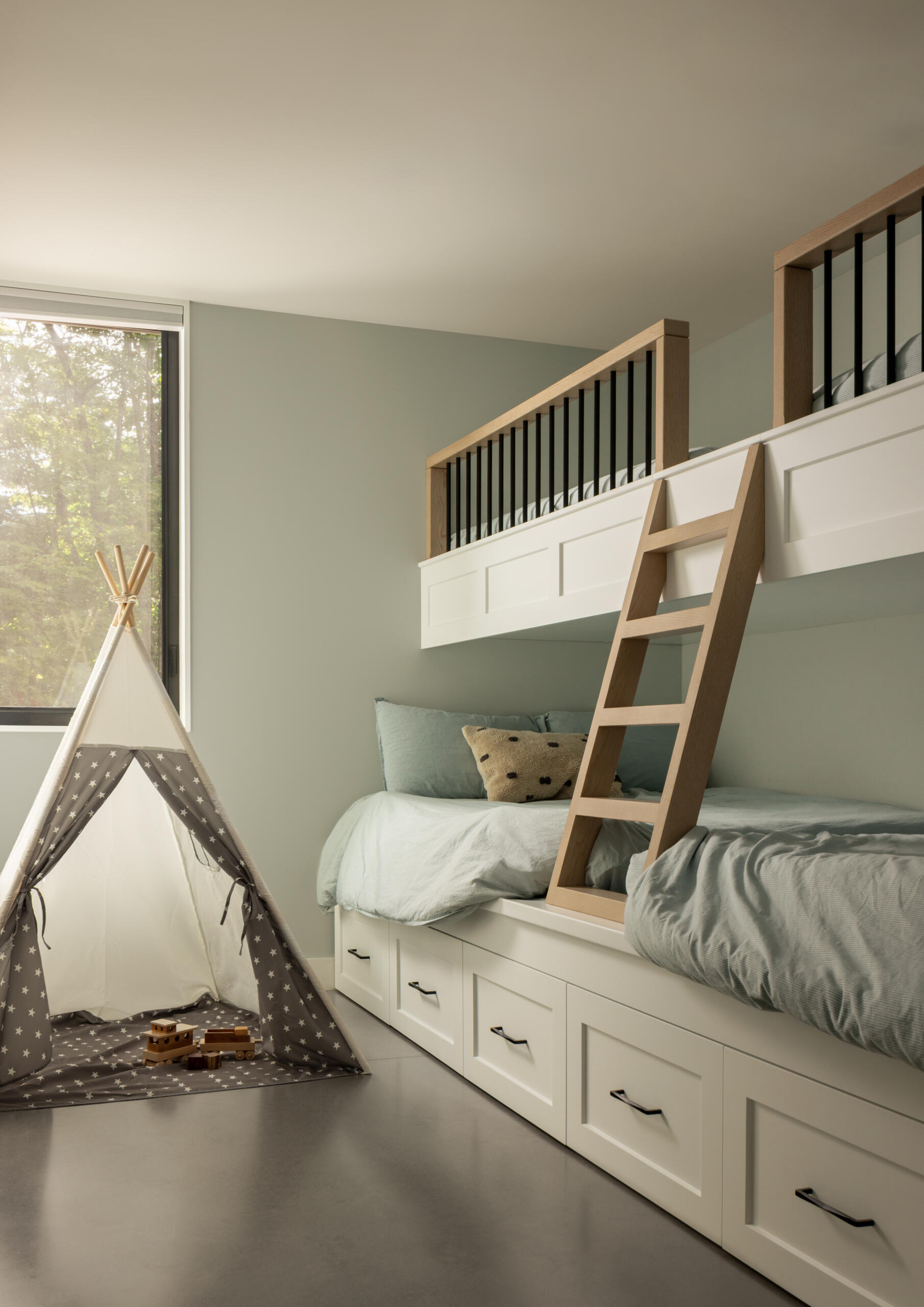 The bunk room offers a playful yet practical solution for a young family, blending privacy with moments of togetherness. Windows are carefully placed to give quiet forest outlooks, balancing the openness of the lake-facing rooms.