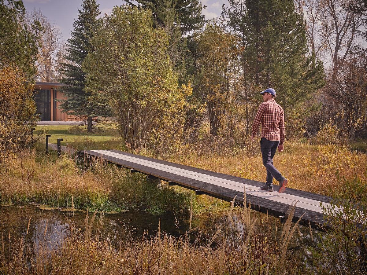 A thoughtful transformation at Rainbow Trout blends rustic and modern architecture with the addition of a bridge, a guest house, and garage.