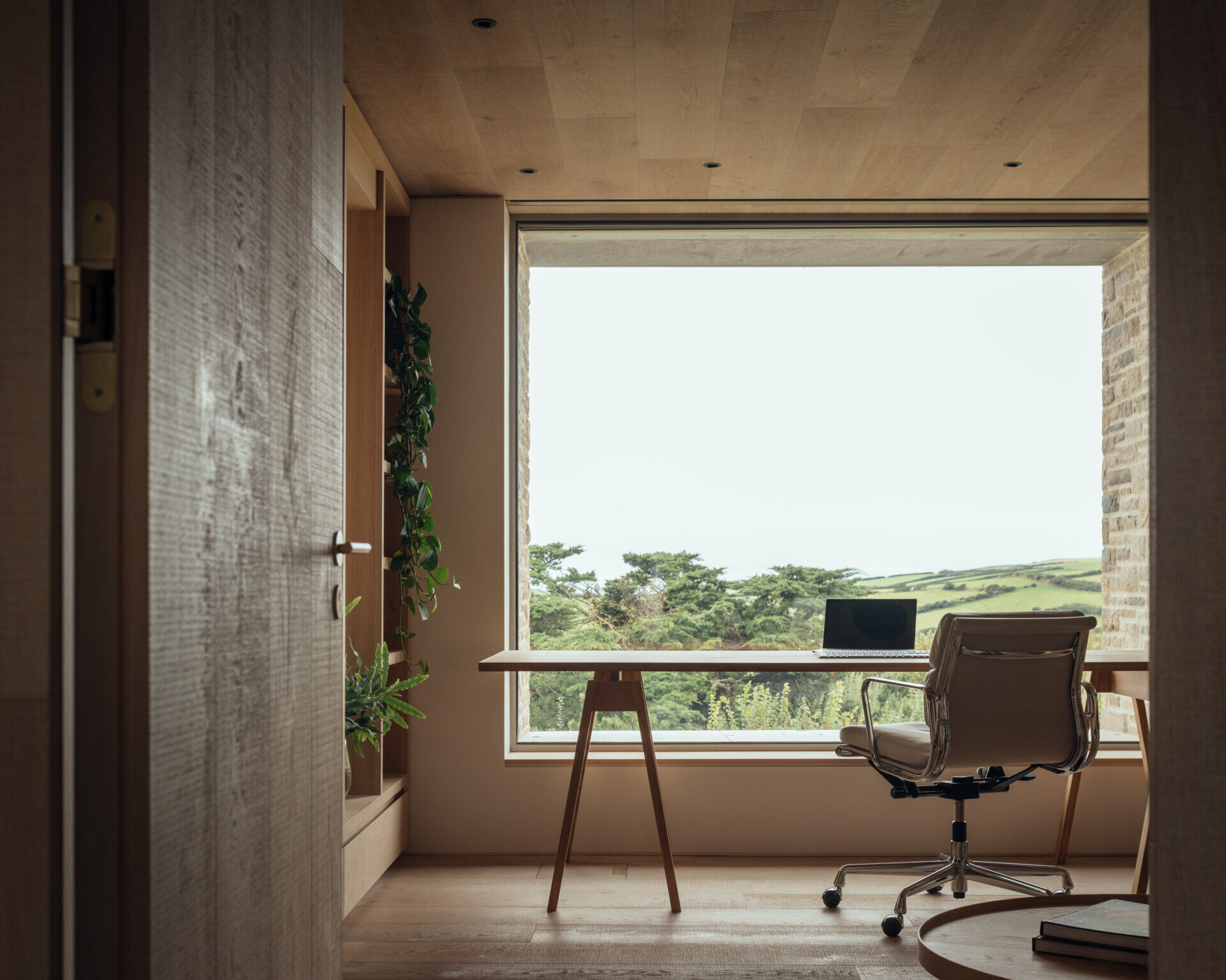 Positioned between active and quiet areas of the home, the study provides a buffer from the utility spaces. Large windows frame the view, offering a calm backdrop for focused work or reading.