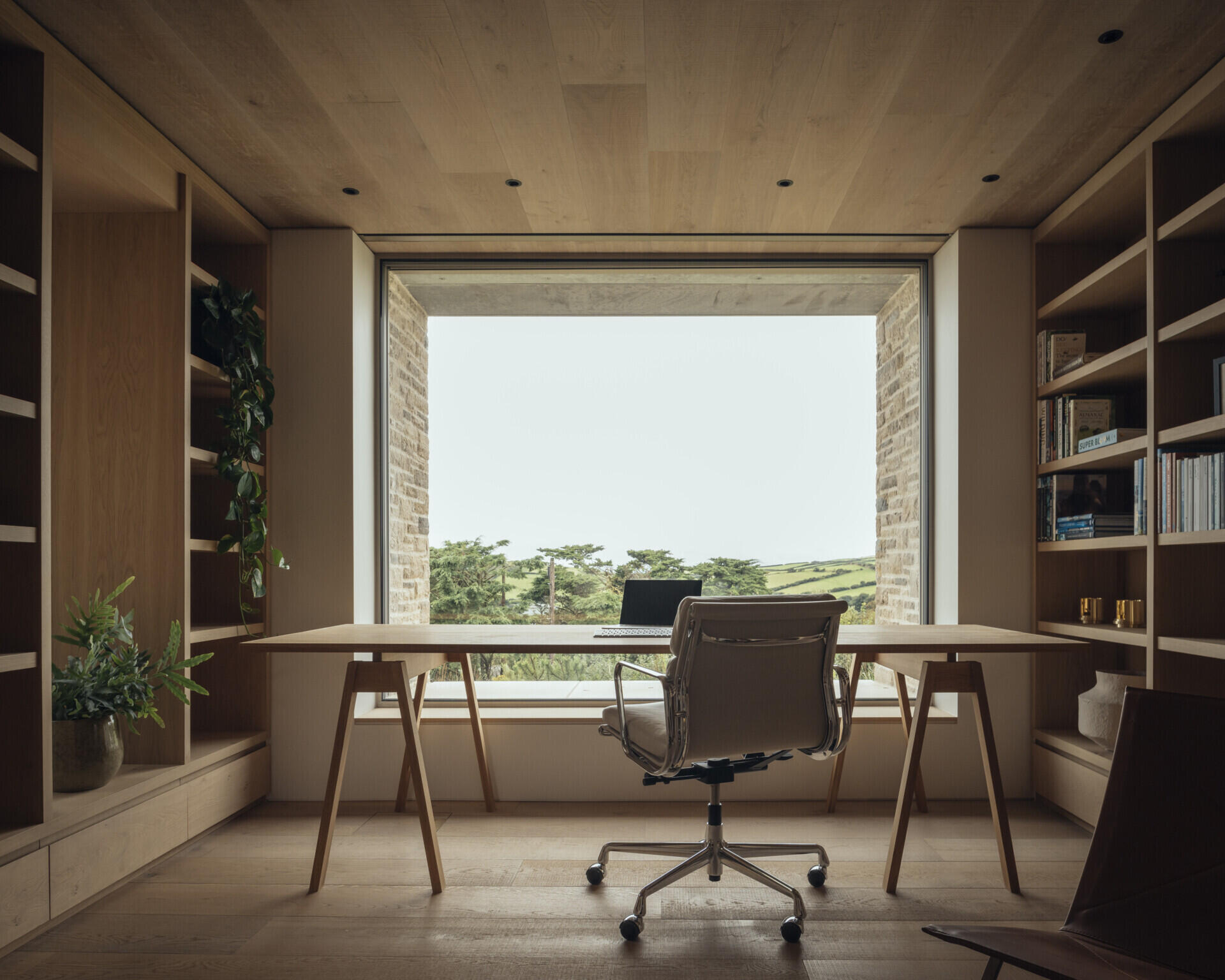 Positioned between active and quiet areas of the home, the study provides a buffer from the utility spaces. Large windows frame the view, offering a calm backdrop for focused work or reading.