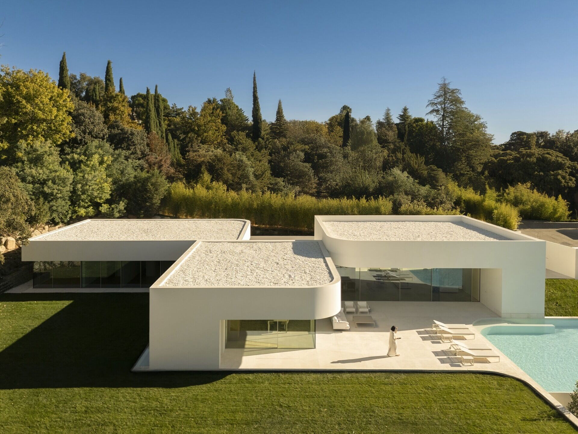 Three volumes define the architecture of this Madrid home, with structural geometry that opens unobstructed views and a palette of warm whites.