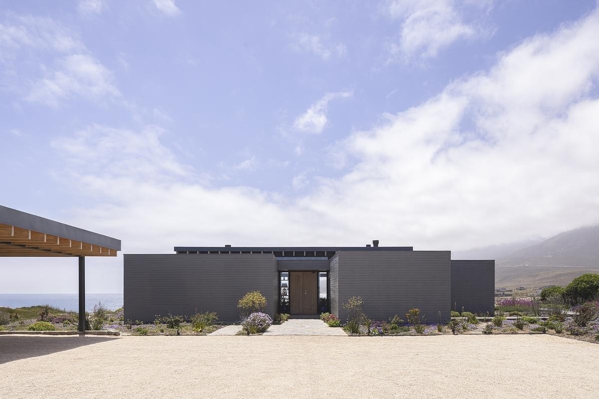 Wooden boxes and concrete walls come together in a minimalist coastal home design.