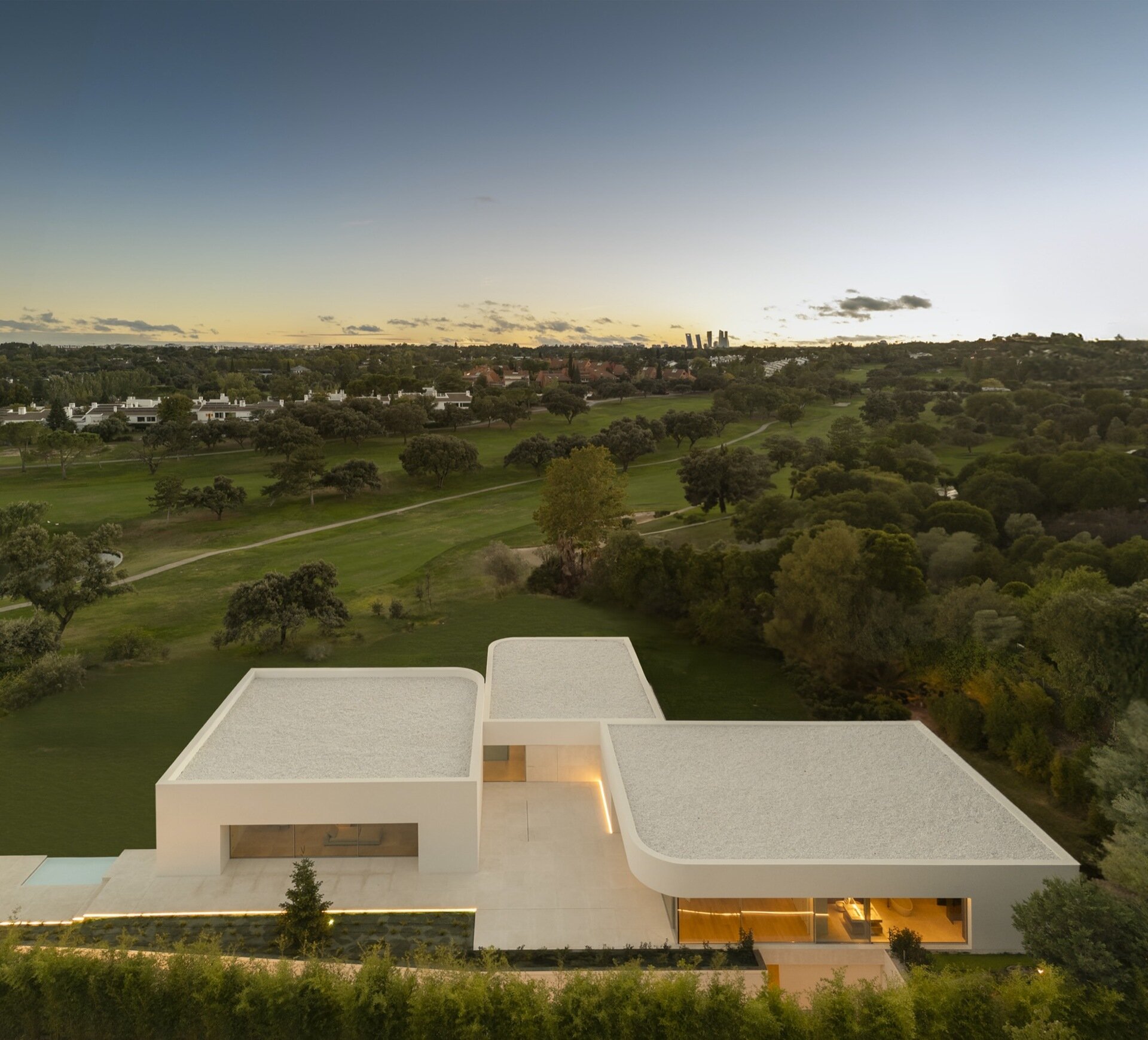 Three volumes define the architecture of this Madrid home, with structural geometry that opens unobstructed views and a palette of warm whites.