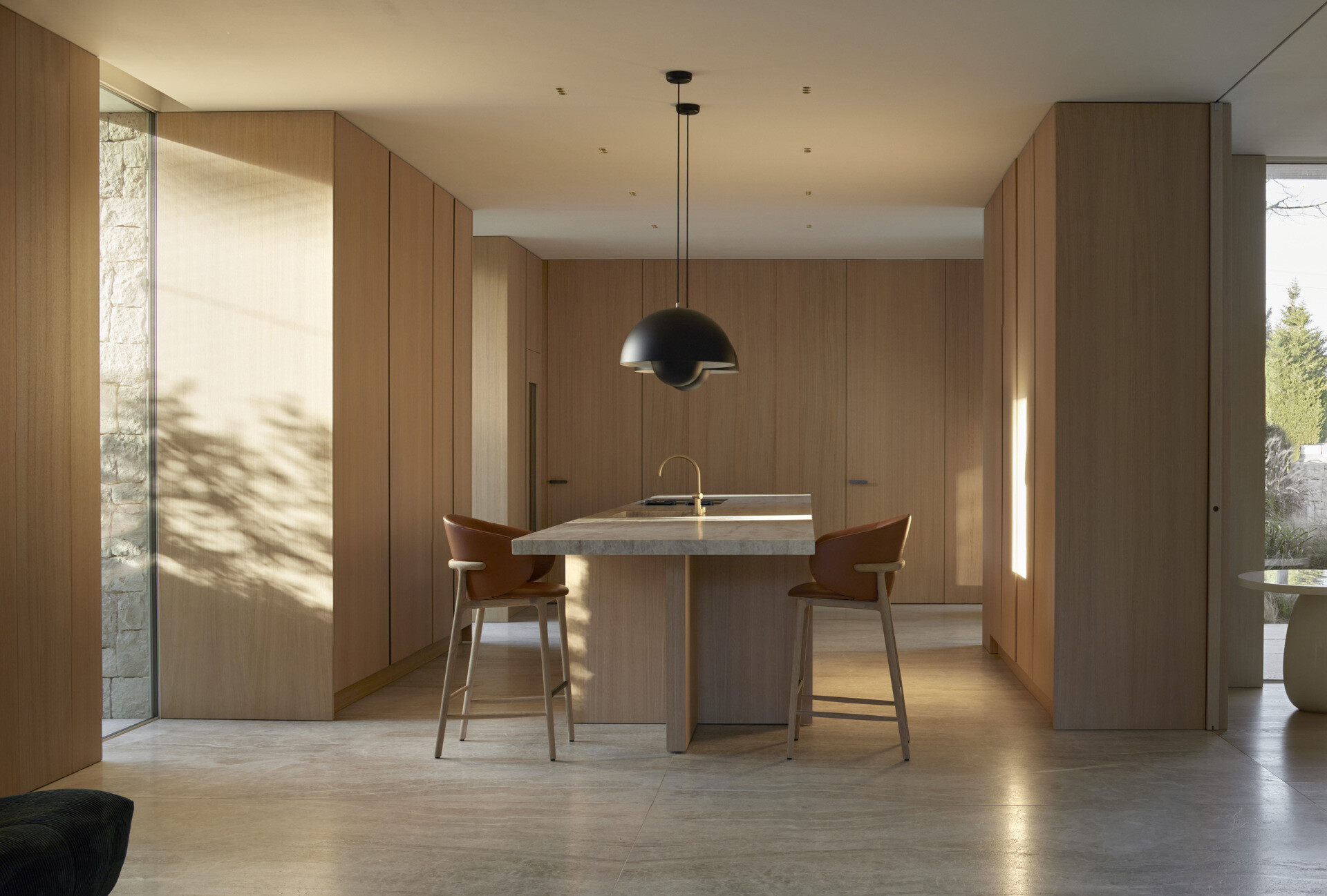 A bright, fluid kitchen with wood cabinets and a central island.