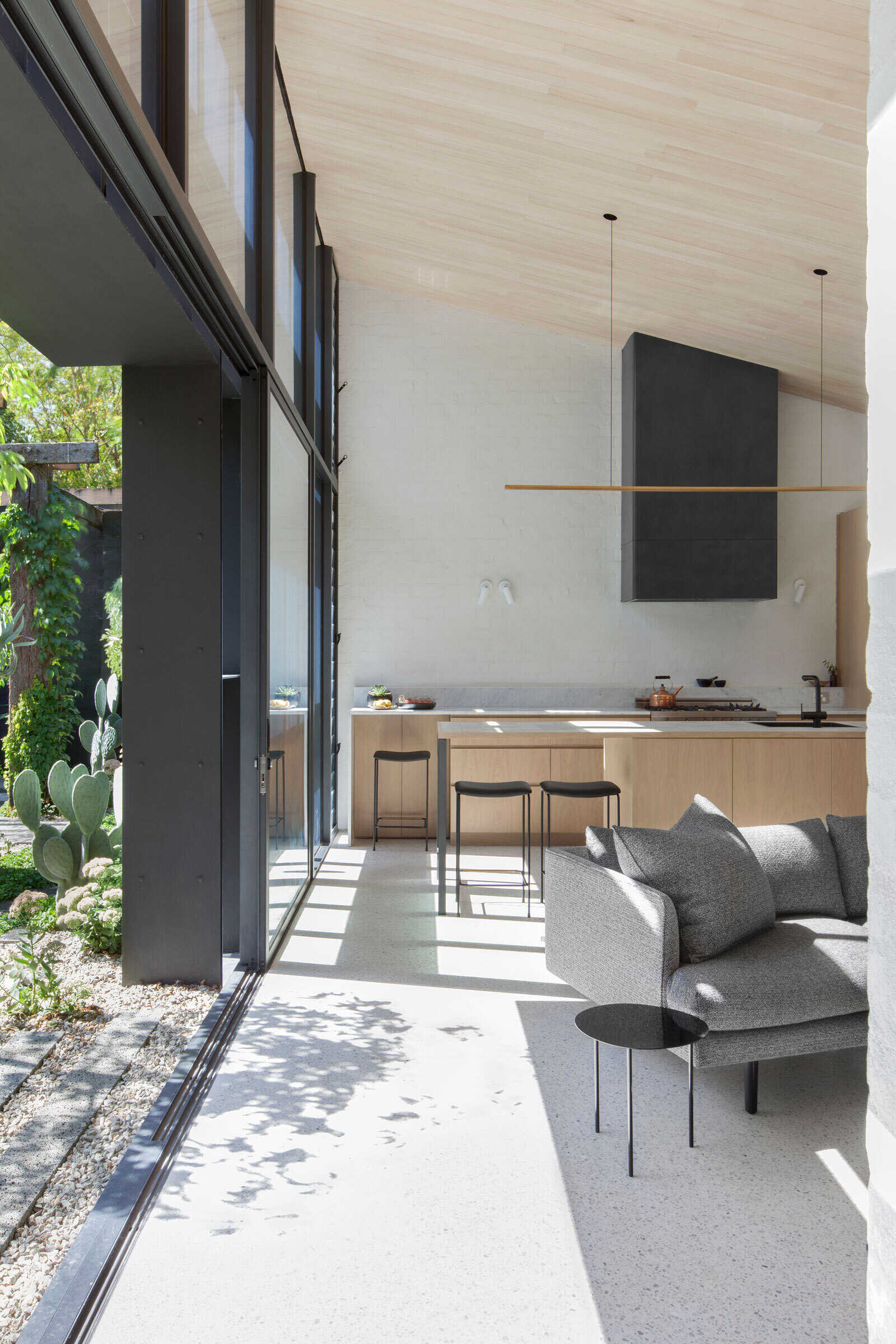 Light wood cabinets and countertops, accented with black details, create a fresh contemporary kitchen.