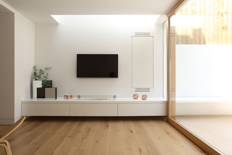 To brighten the once-dark lower ground floor, a skylight was added above the living area. This not only floods the interior with daylight but also draws attention to the newly opened connection to the garden at the back of the house.