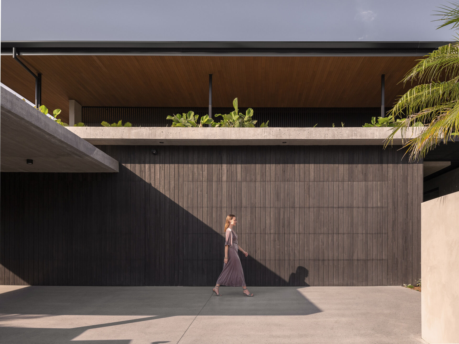 The entryway feels both private and welcoming, leading guests from a sheltered threshold into the heart of the house. The garage is integrated seamlessly, supporting the family’s daily life without interrupting the architectural flow.