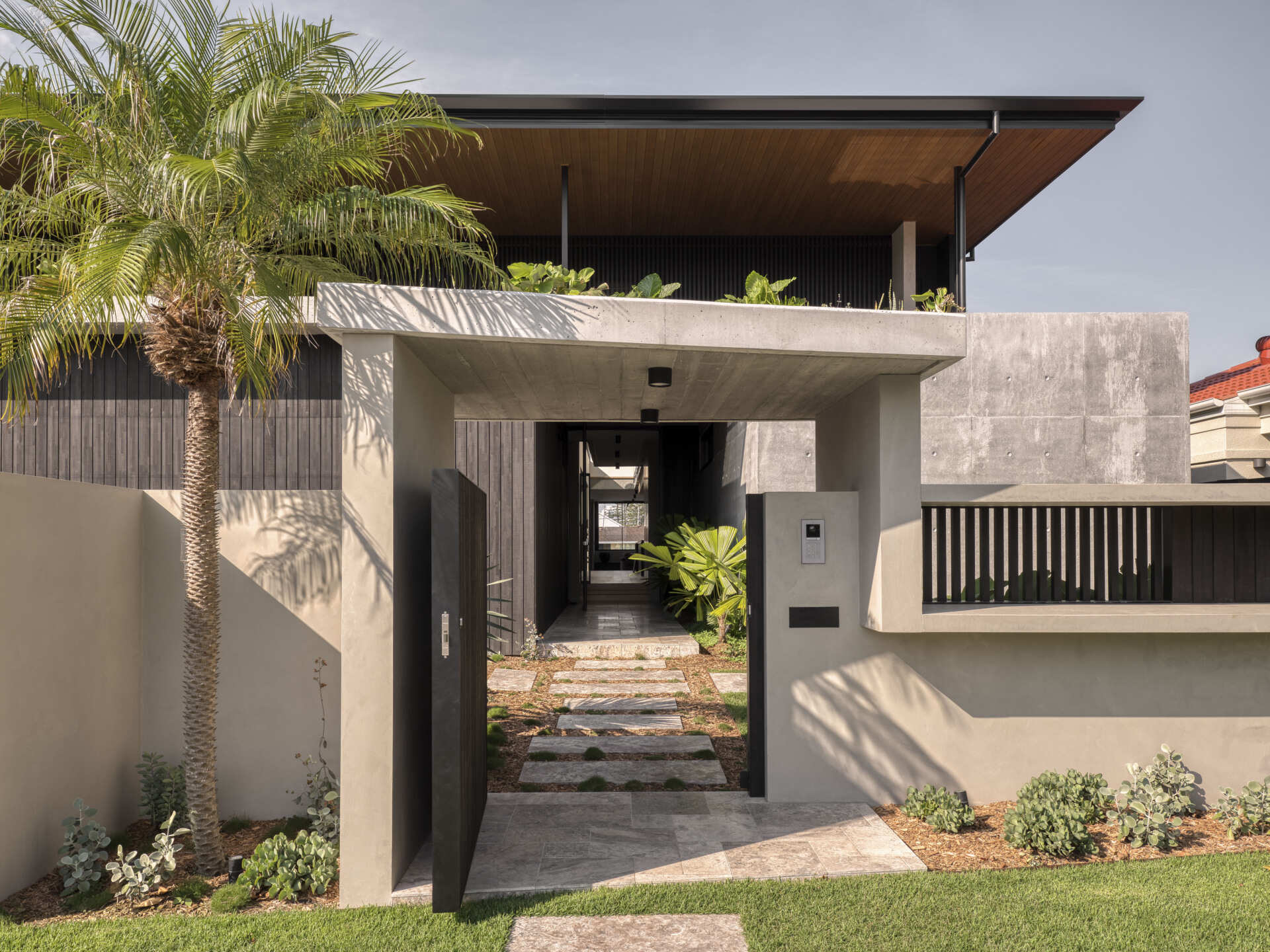 The entryway feels both private and welcoming, leading guests from a sheltered threshold into the heart of the house. The garage is integrated seamlessly, supporting the family’s daily life without interrupting the architectural flow.