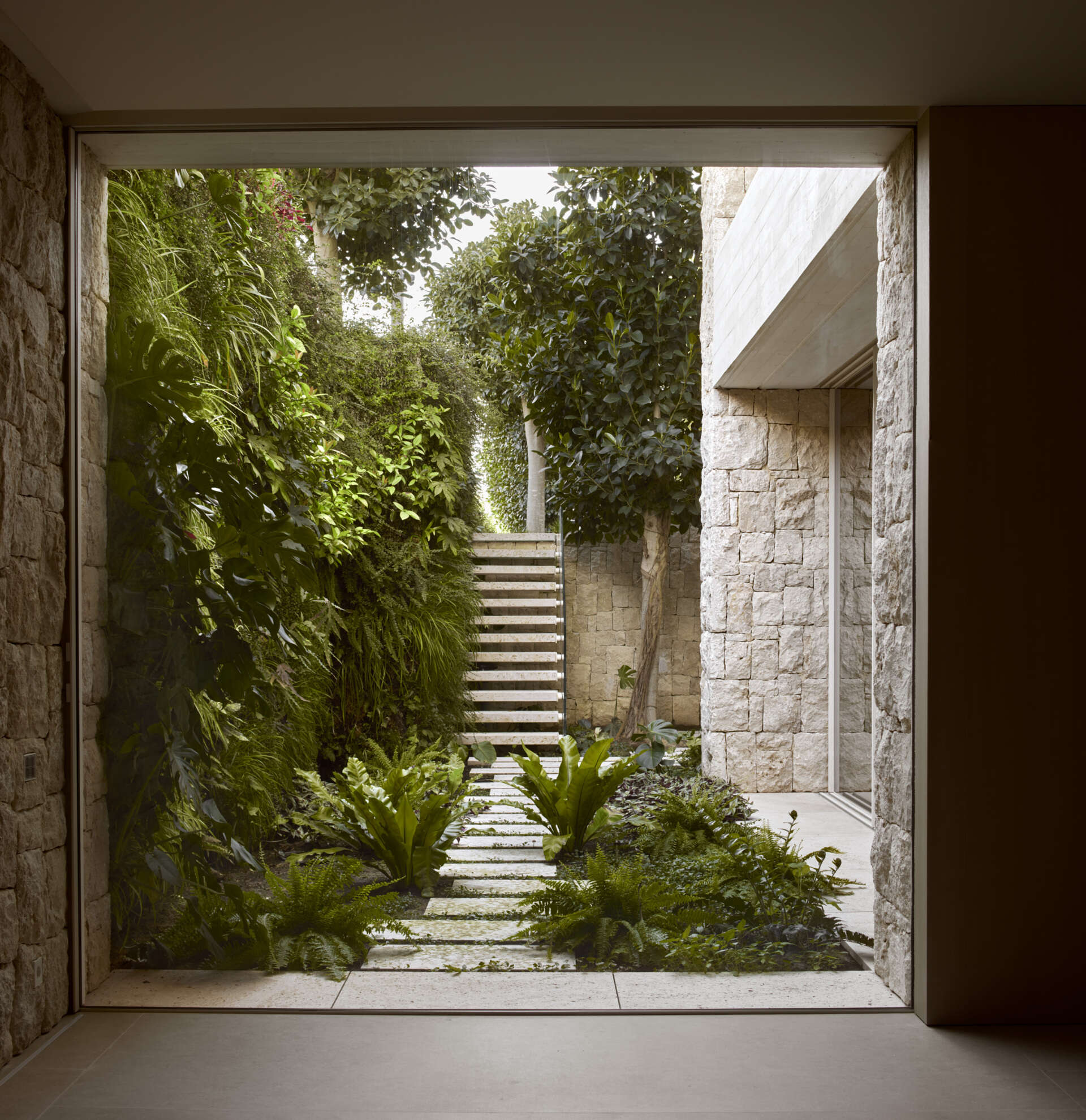 Expansive picture windows frame views of the garden and courtyard.