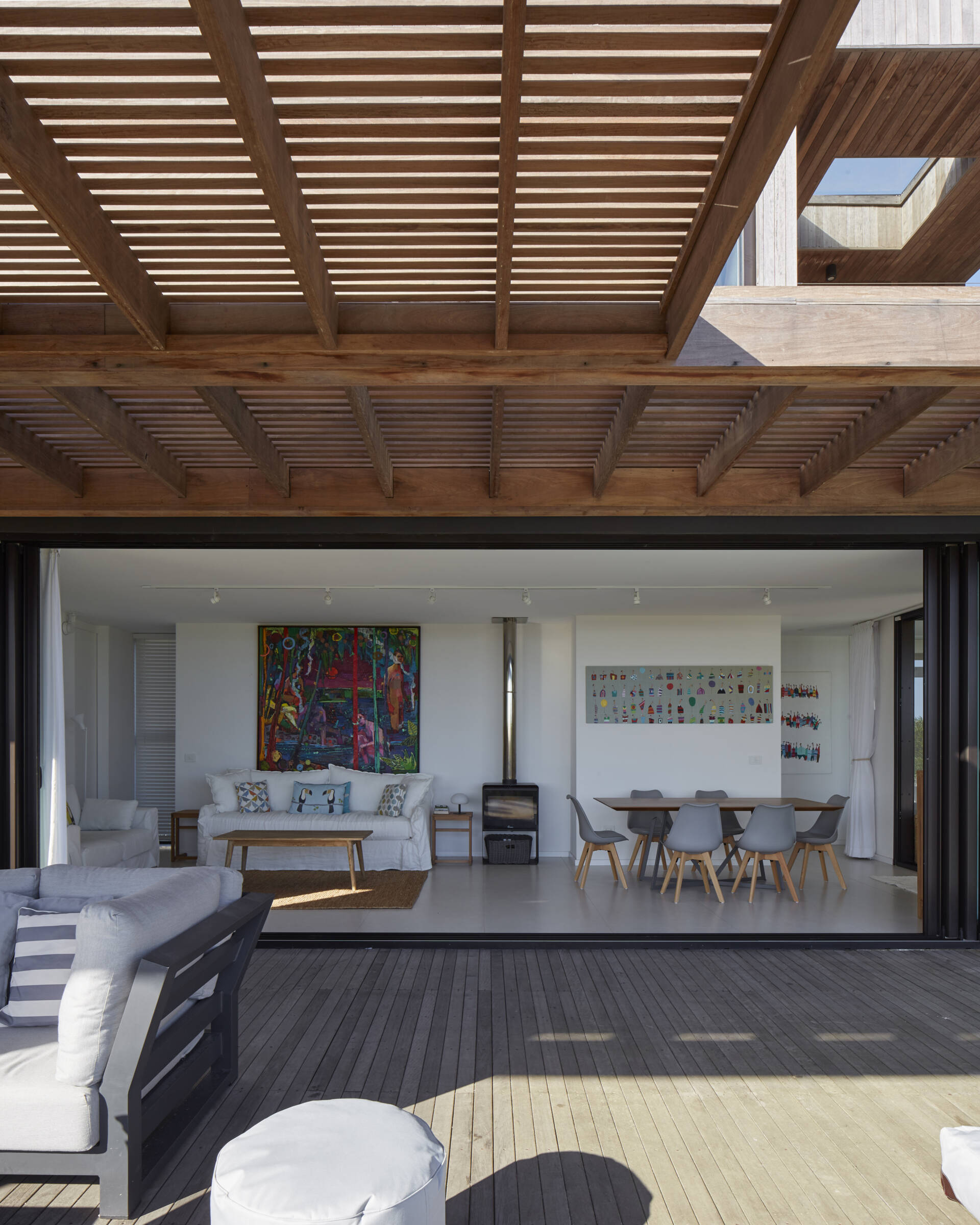 This prefabricated modular house, clad in wood, orientates each room, like the living room and dining area, towards the pool and beach.