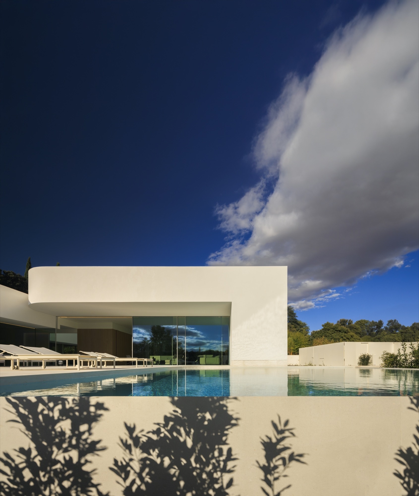 The outdoor pool is designed as an extension of the architecture, with clean lines that mirror the home’s sculptural facade. 