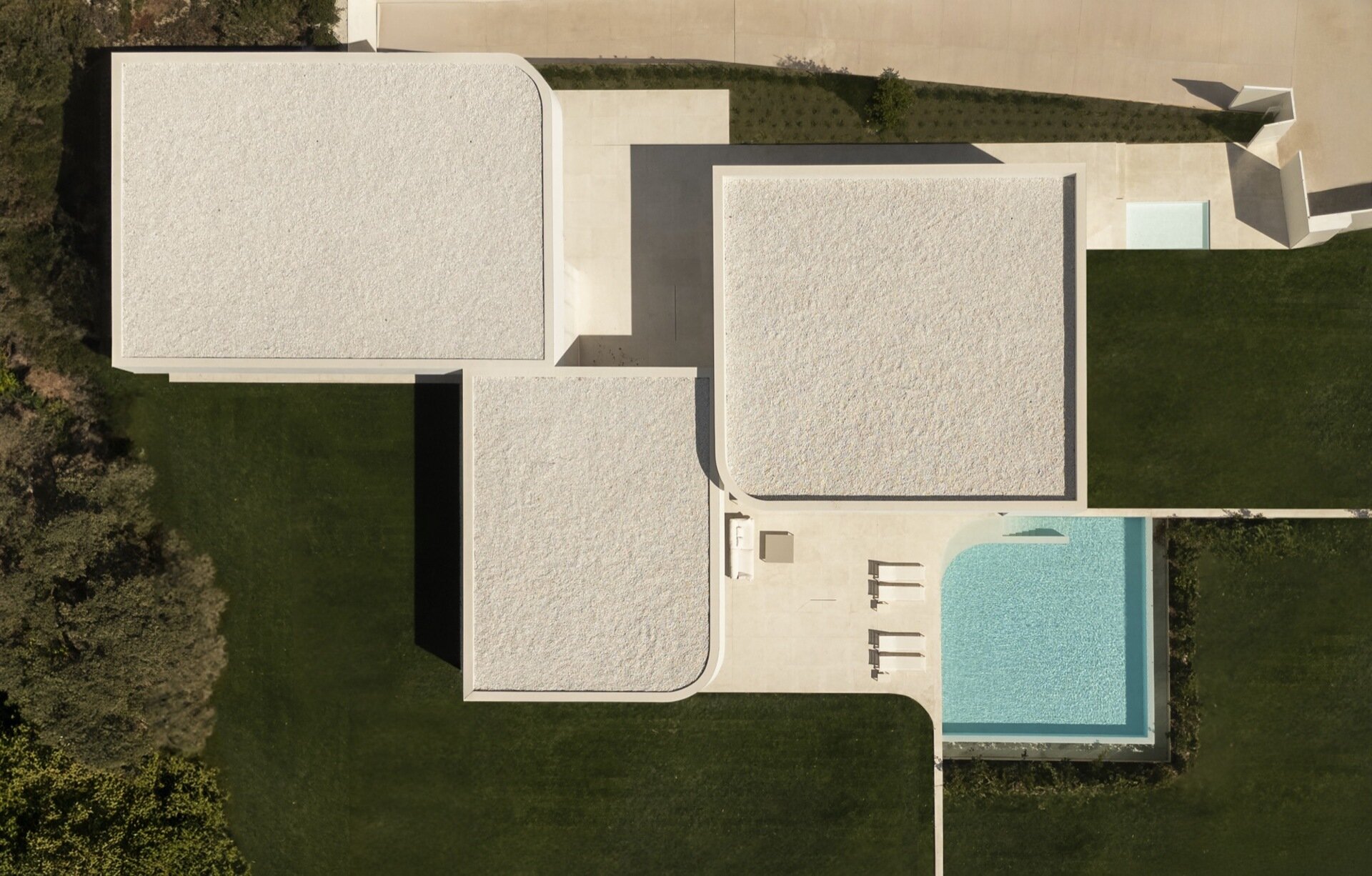 The outdoor pool is designed as an extension of the architecture, with clean lines that mirror the home’s sculptural facade. 