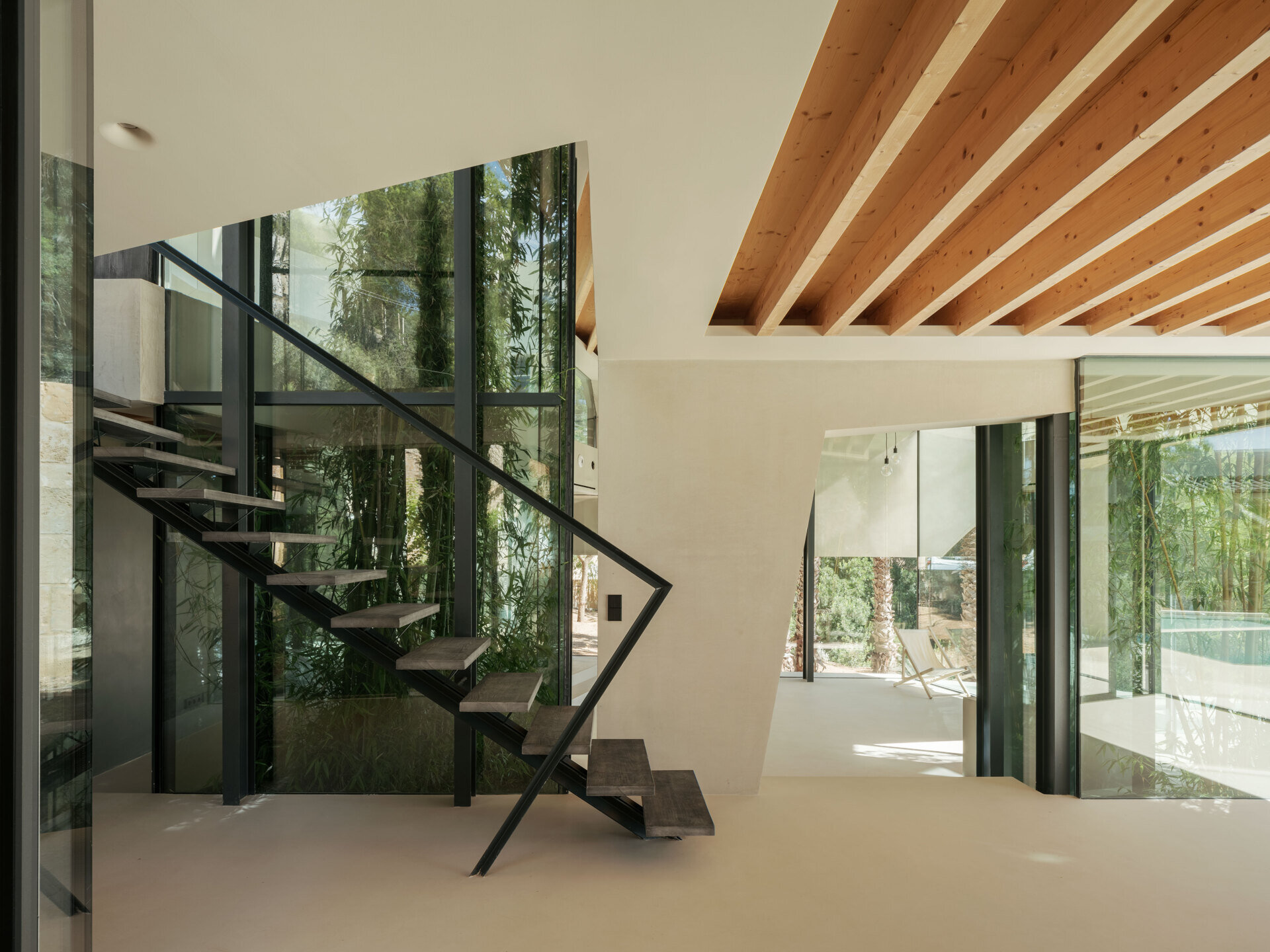 Step inside a home where nature replaces walls. Courtyards and glass fissures bring plants and light directly into the living spaces.