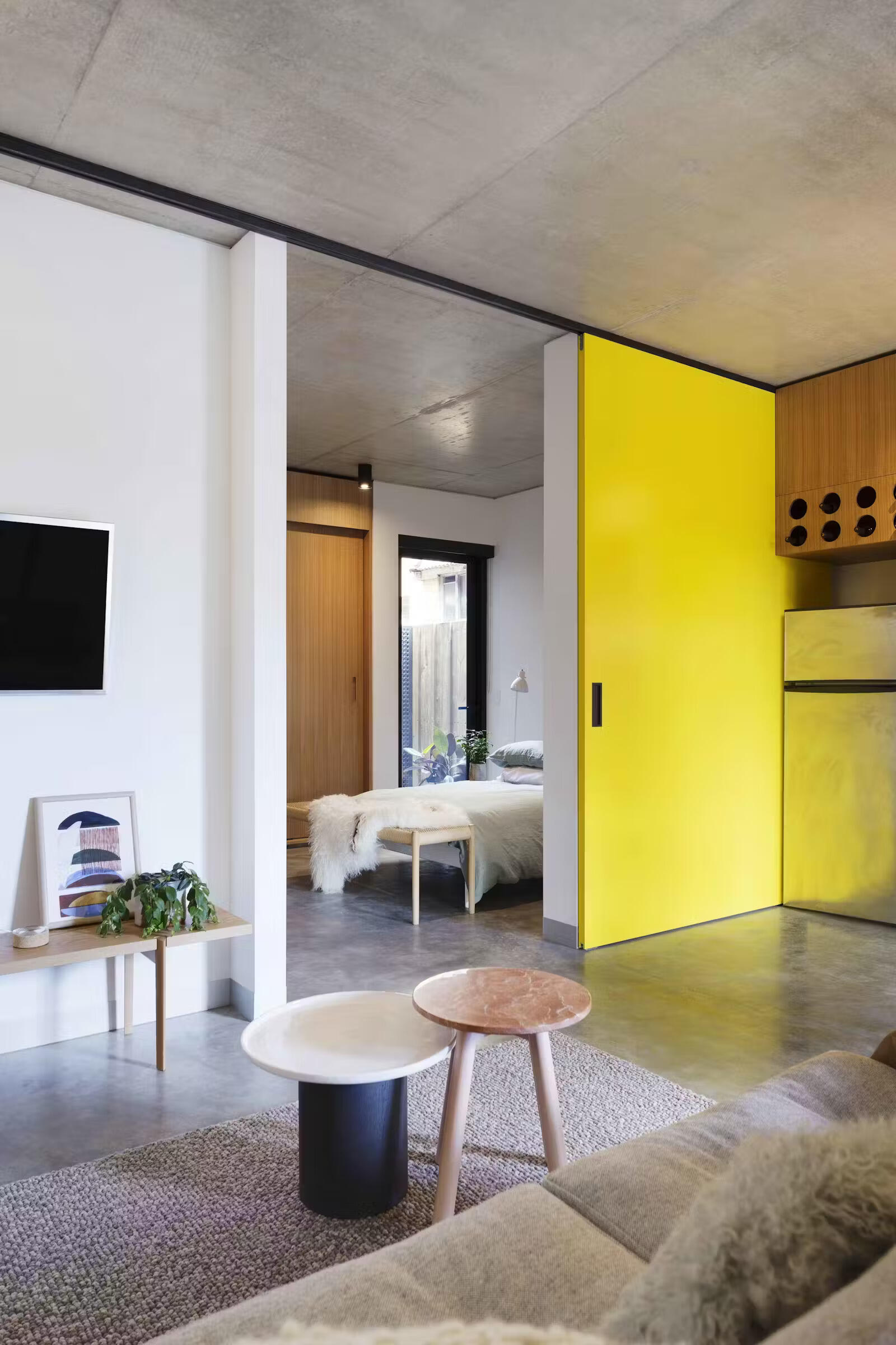 Bold yellow sliding doors reveal the bedroom in this apartment.