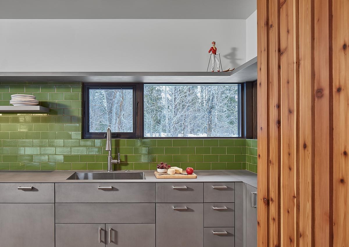 Inside the guest house, natural light, living room, and a small kitchen make the space both bright and practical.