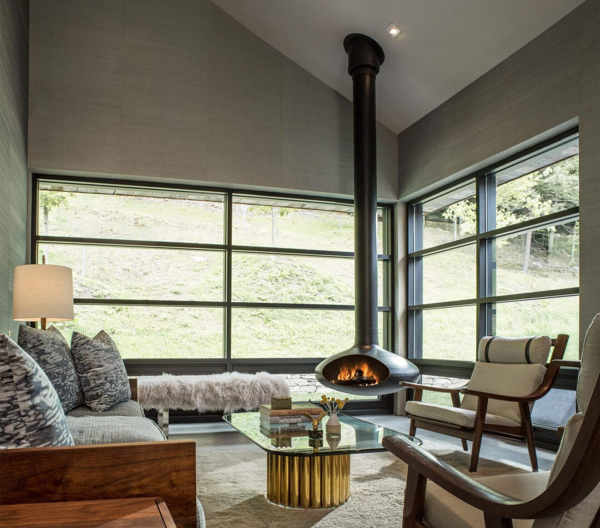The guest side of the house includes two ensuite bedrooms, a kitchen, and a living space with a striking hanging fireplace.
