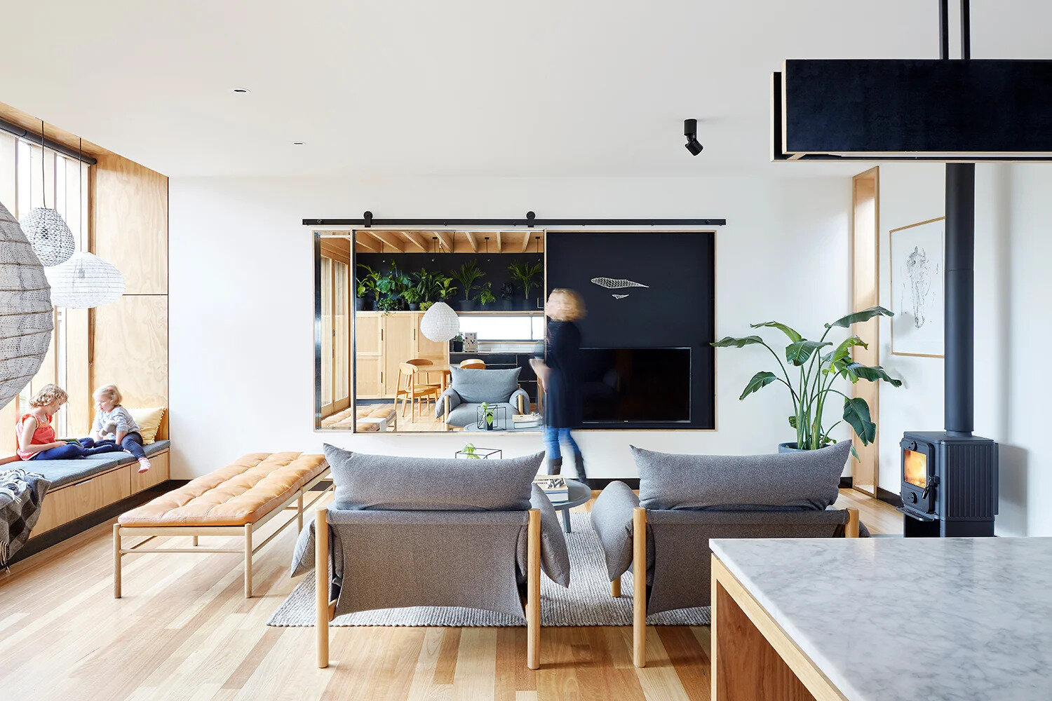 One of the extension’s standout features is a built-in window seat tucked beside the living room. Framed by tall north-facing windows, it’s a perfect sunlit nook to read, relax, or simply gaze into the garden. The seat also hides discreet storage beneath an upholstered cushion, marrying comfort with practicality.