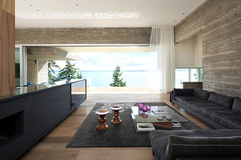 Minimalist living room design with a low-profile sofa and hidden TV in a modern oceanfront house.