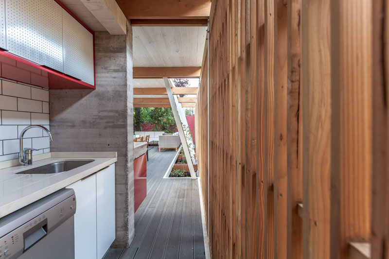 Compact yet functional kitchenette within the enclosed section of this modern pool house makes poolside entertaining effortless.