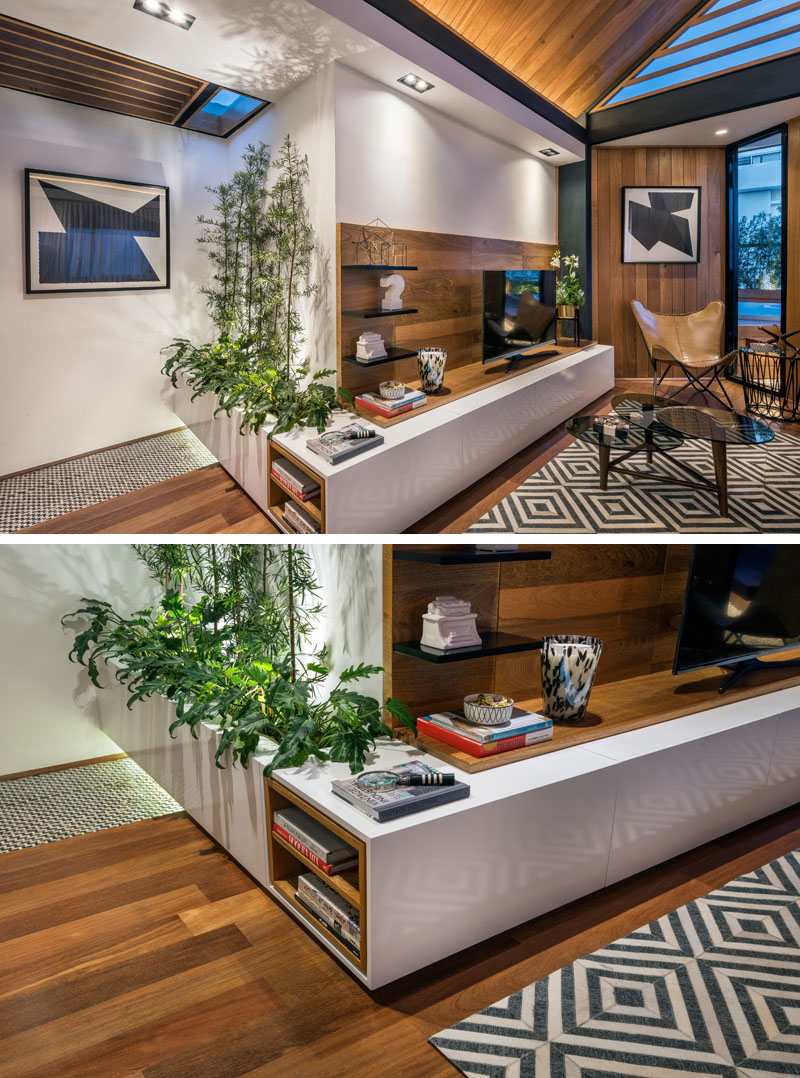Step inside an indoor space with a gabled wood ceiling, hidden lighting, and greenery throughout.