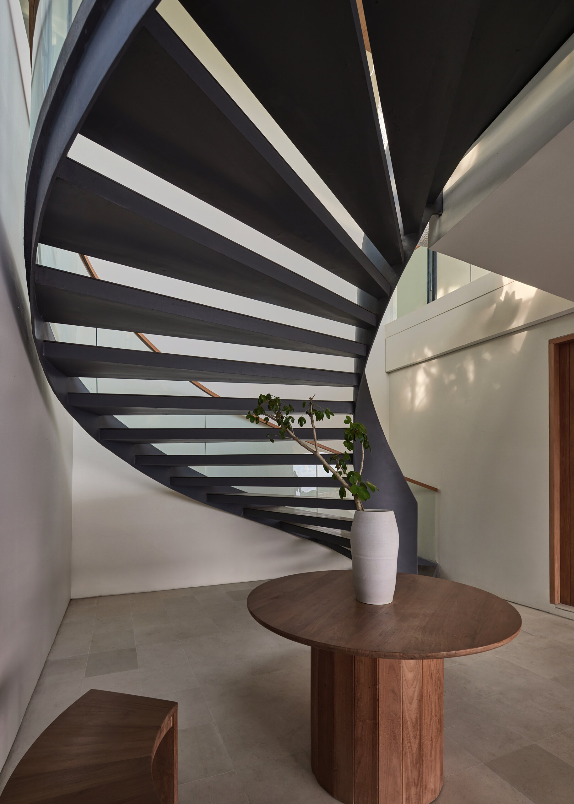 A series of steps and platforms connect each level, creating a rhythm that mirrors the contours of the site. These pathways move residents from communal areas to private quarters in a way that feels both practical and sculptural.