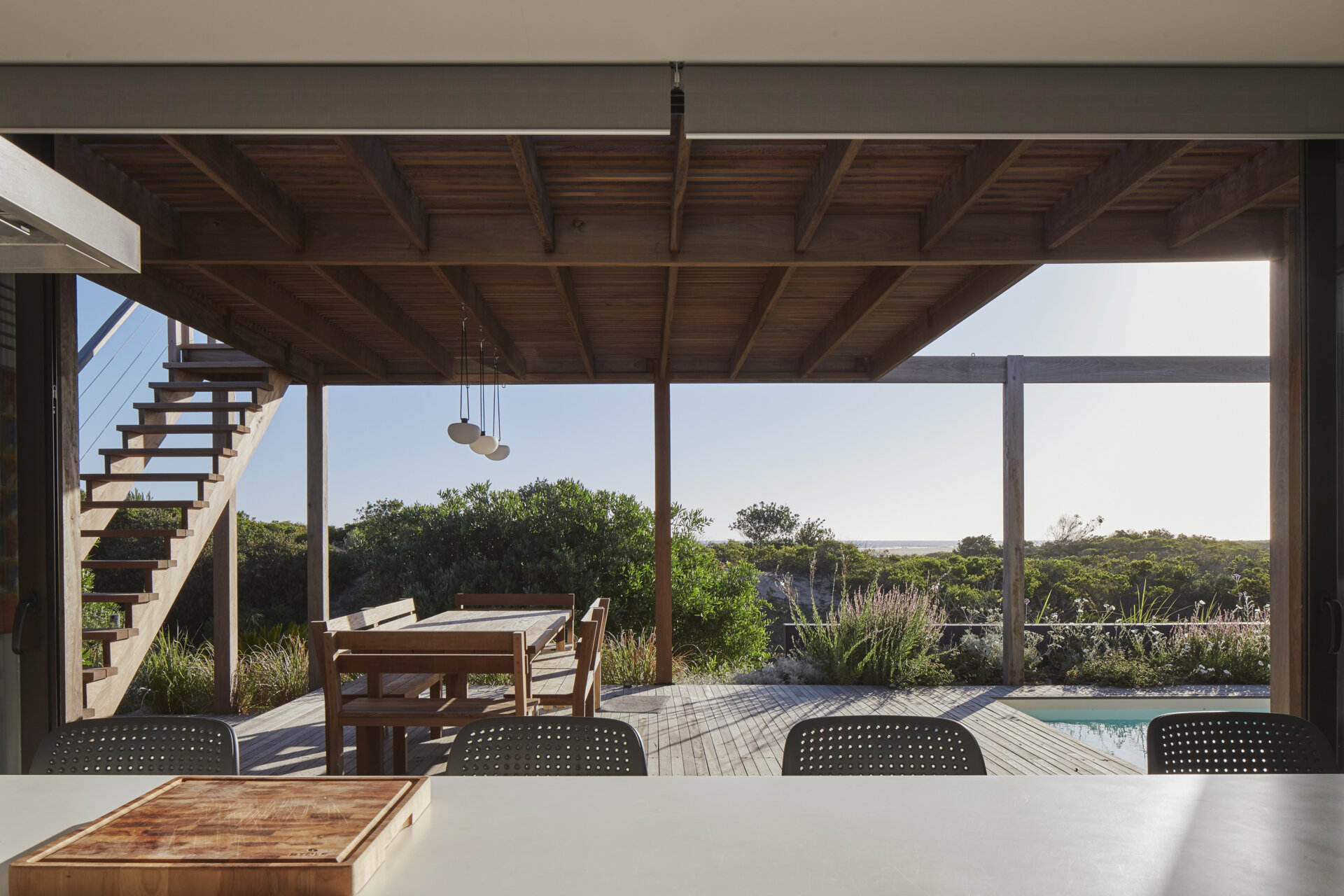 Sliding doors open to connect the kitchen with a covered outdoor dining area.