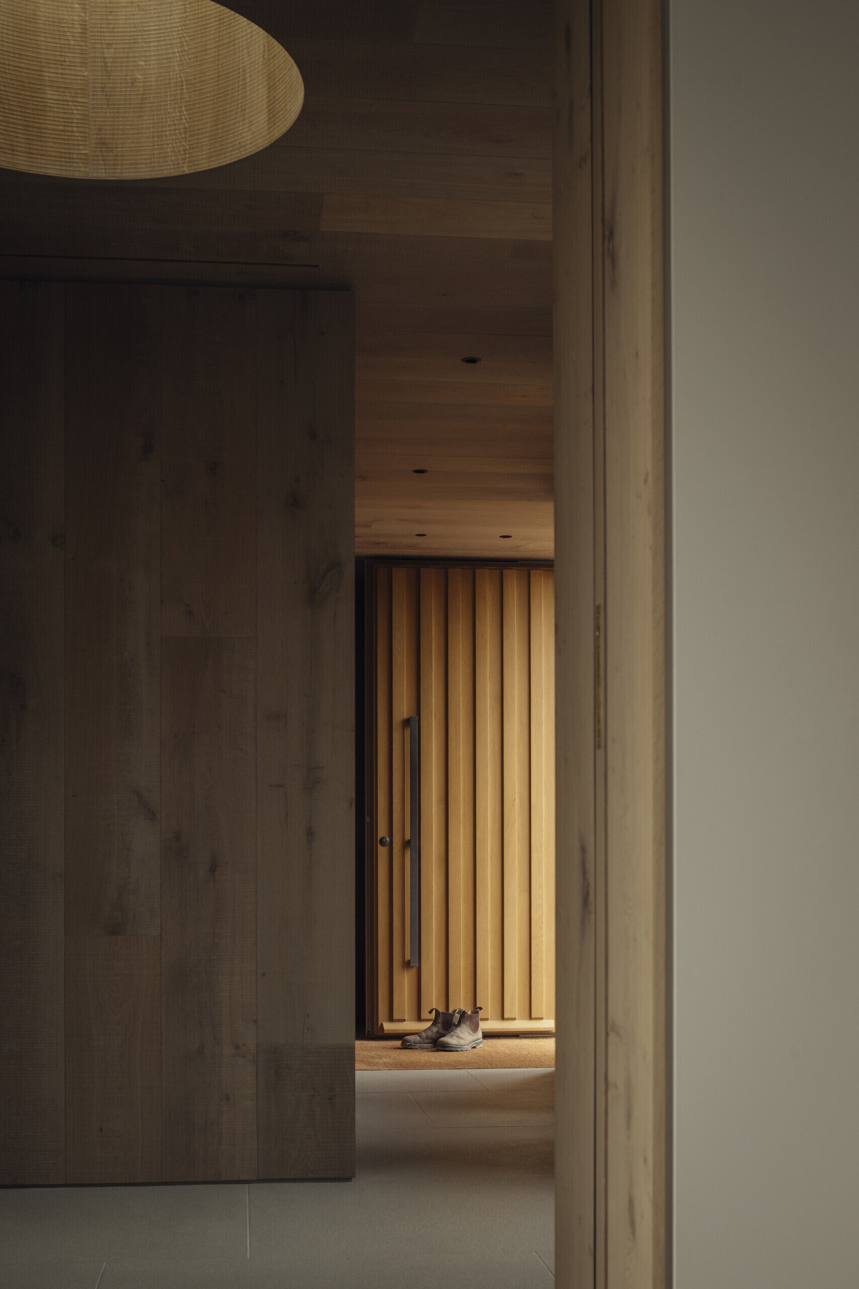 The wood front door opens to an entry hall with floor-to-ceiling glass overlooking a sheltered courtyard.