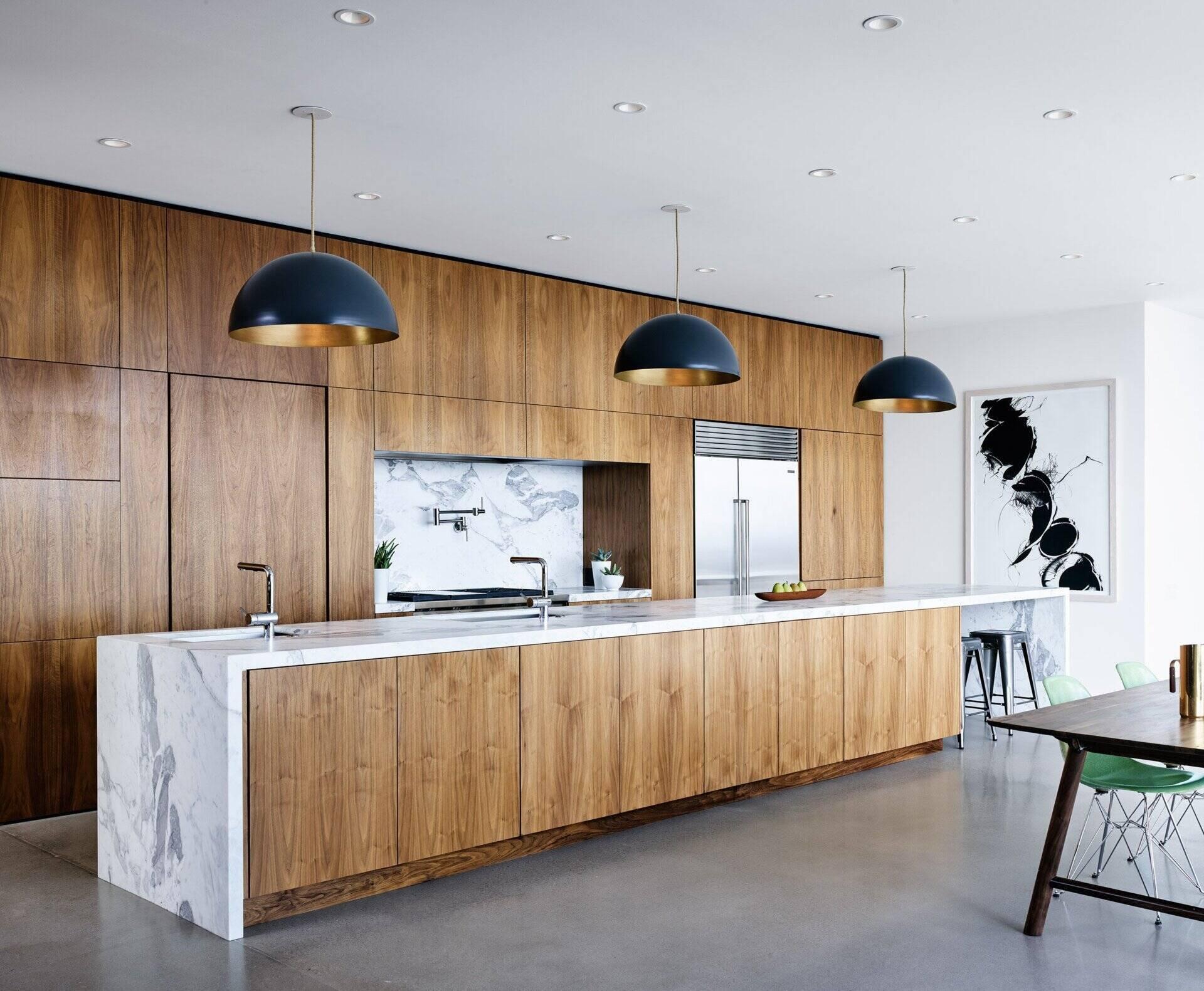 Polished concrete floors, walnut cabinetry, and marble accents define the kitchen of this modern mountain home.