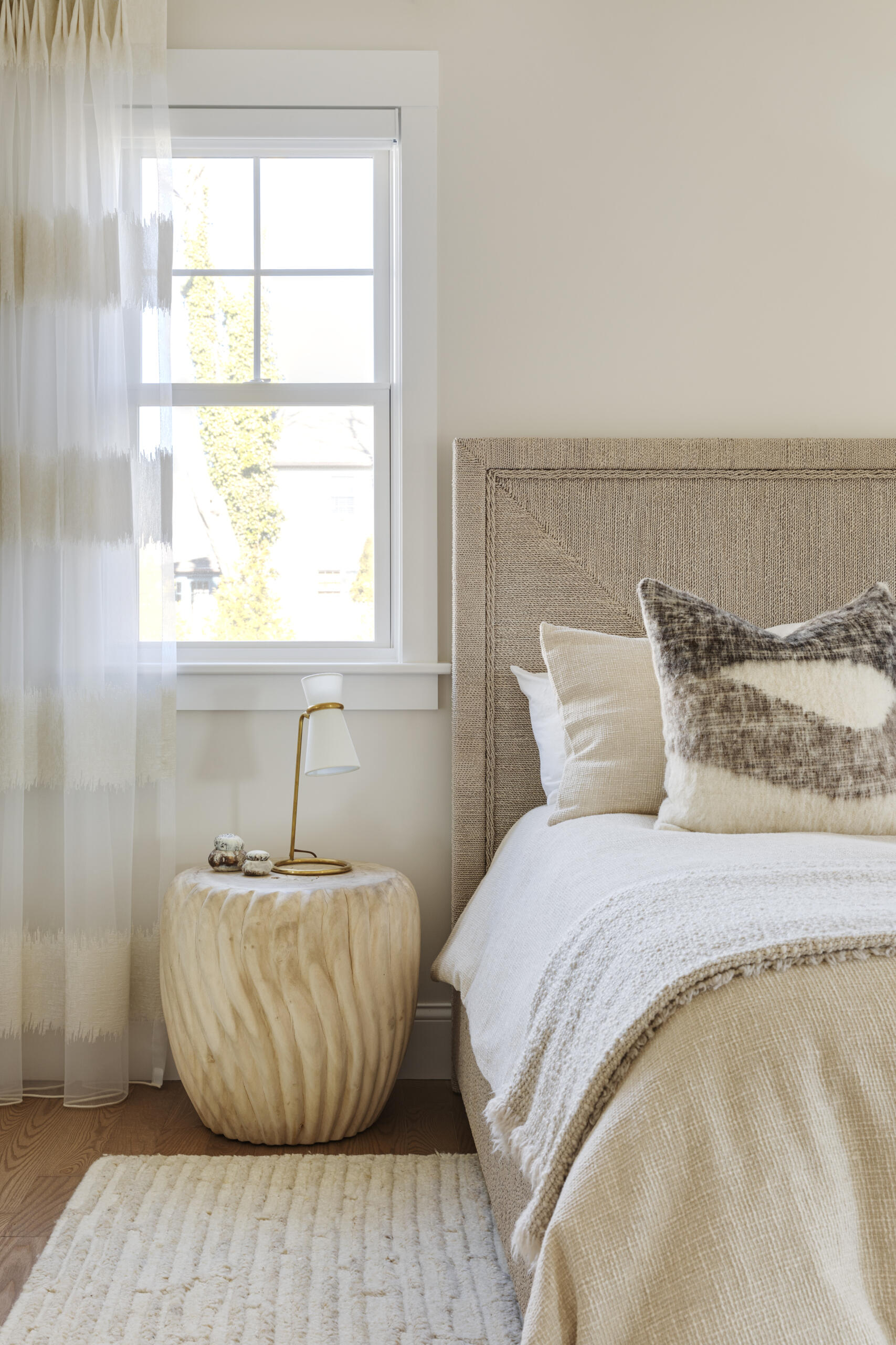 In the bedrooms of this Cape Cod home, the clients’ sentimental artwork was carefully reframed to give each piece a fresh, modern presence that complements the new design. Natural materials like wicker and rattan, gentle pops of green, and softly curved furniture tie the rooms to the coastal surroundings.