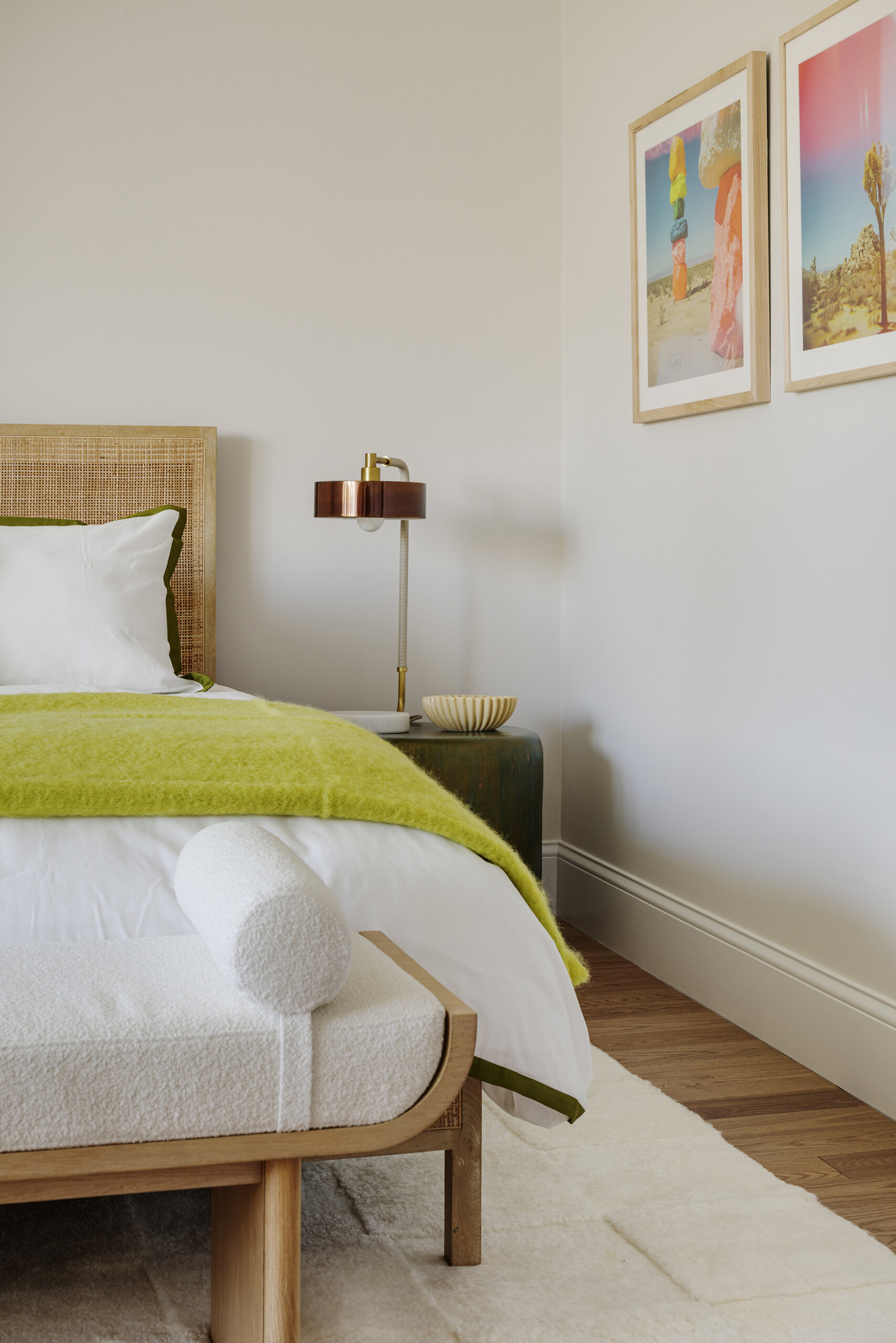 In the bedrooms of this Cape Cod home, the clients’ sentimental artwork was carefully reframed to give each piece a fresh, modern presence that complements the new design. Natural materials like wicker and rattan, gentle pops of green, and softly curved furniture tie the rooms to the coastal surroundings.