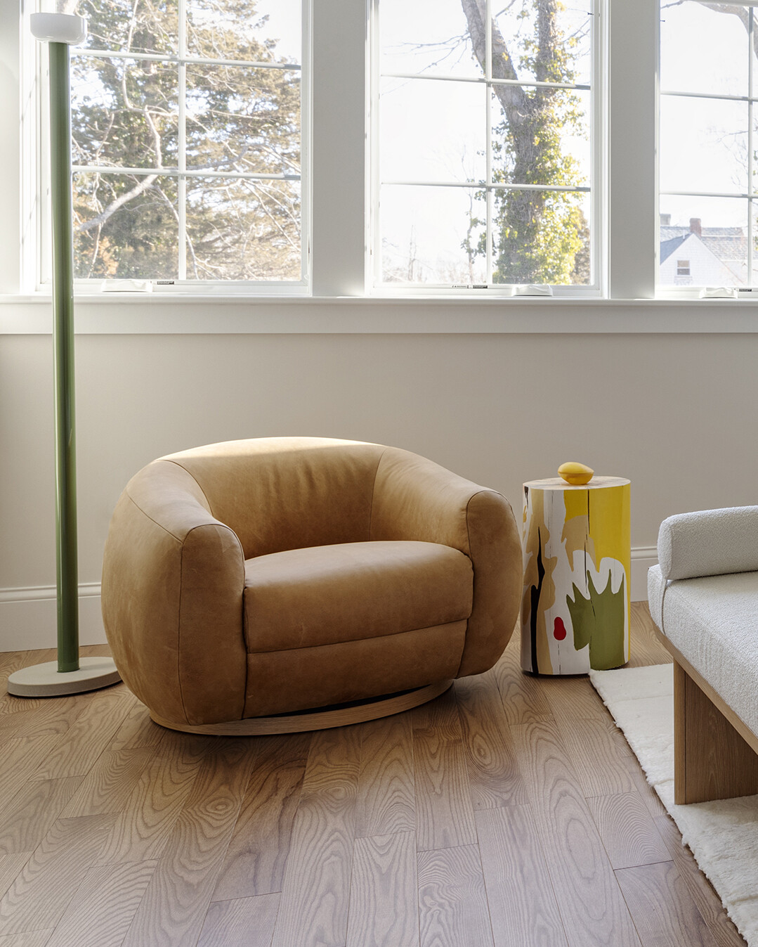In the bedrooms of this Cape Cod home, the clients’ sentimental artwork was carefully reframed to give each piece a fresh, modern presence that complements the new design. Natural materials like wicker and rattan, gentle pops of green, and softly curved furniture tie the rooms to the coastal surroundings.