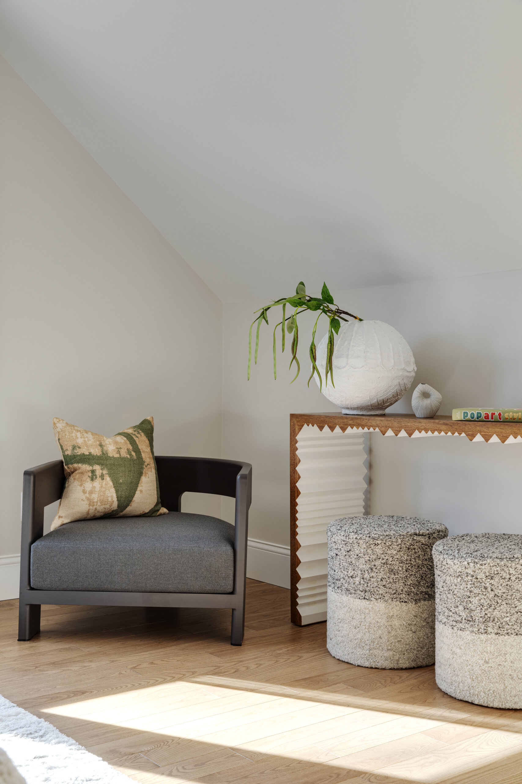 In the bedrooms of this Cape Cod home, the clients’ sentimental artwork was carefully reframed to give each piece a fresh, modern presence that complements the new design. Natural materials like wicker and rattan, gentle pops of green, and softly curved furniture tie the rooms to the coastal surroundings.