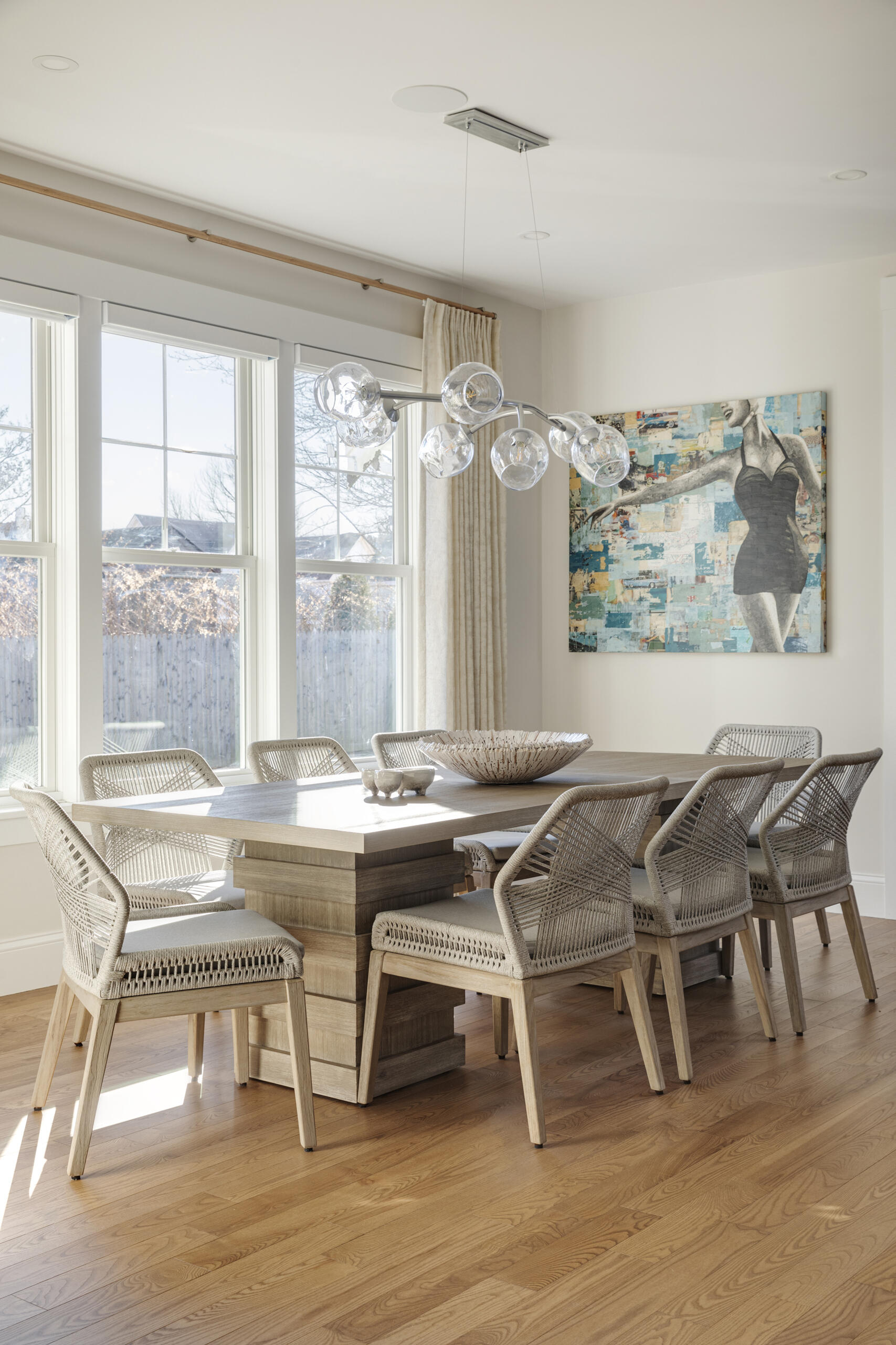 The dining area continues the home’s nature-inspired theme with earthy tones and organic textures that complement the rest of the interiors. Thoughtfully curated furnishings create a comfortable yet refined space for meals and gatherings. Natural light filters through the windows, while a pop of colour from the artwork complements the space.