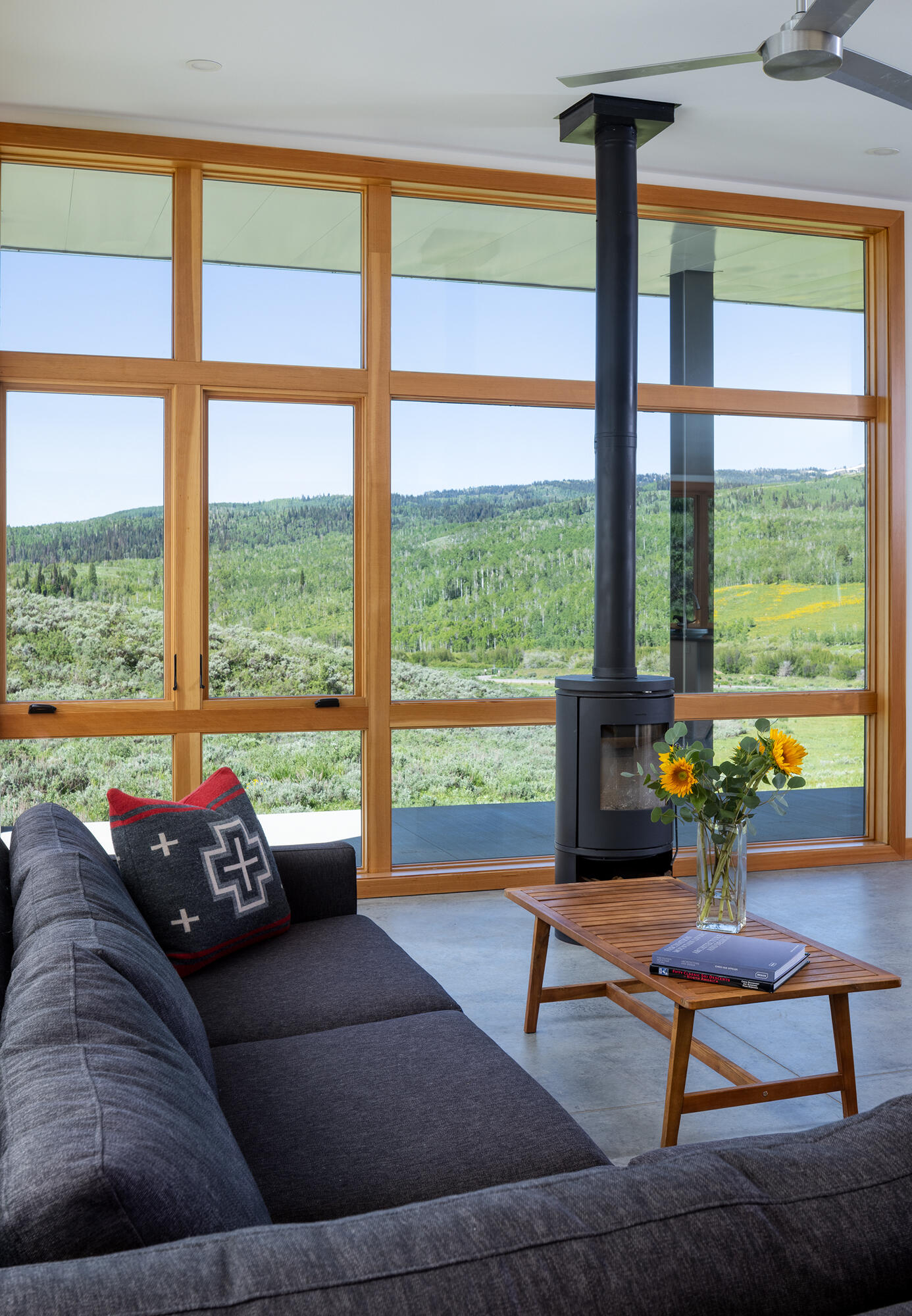 This living room in an off-grid cabin features southwest-facing windows that frame sweeping canyon views and fill the space with natural light.