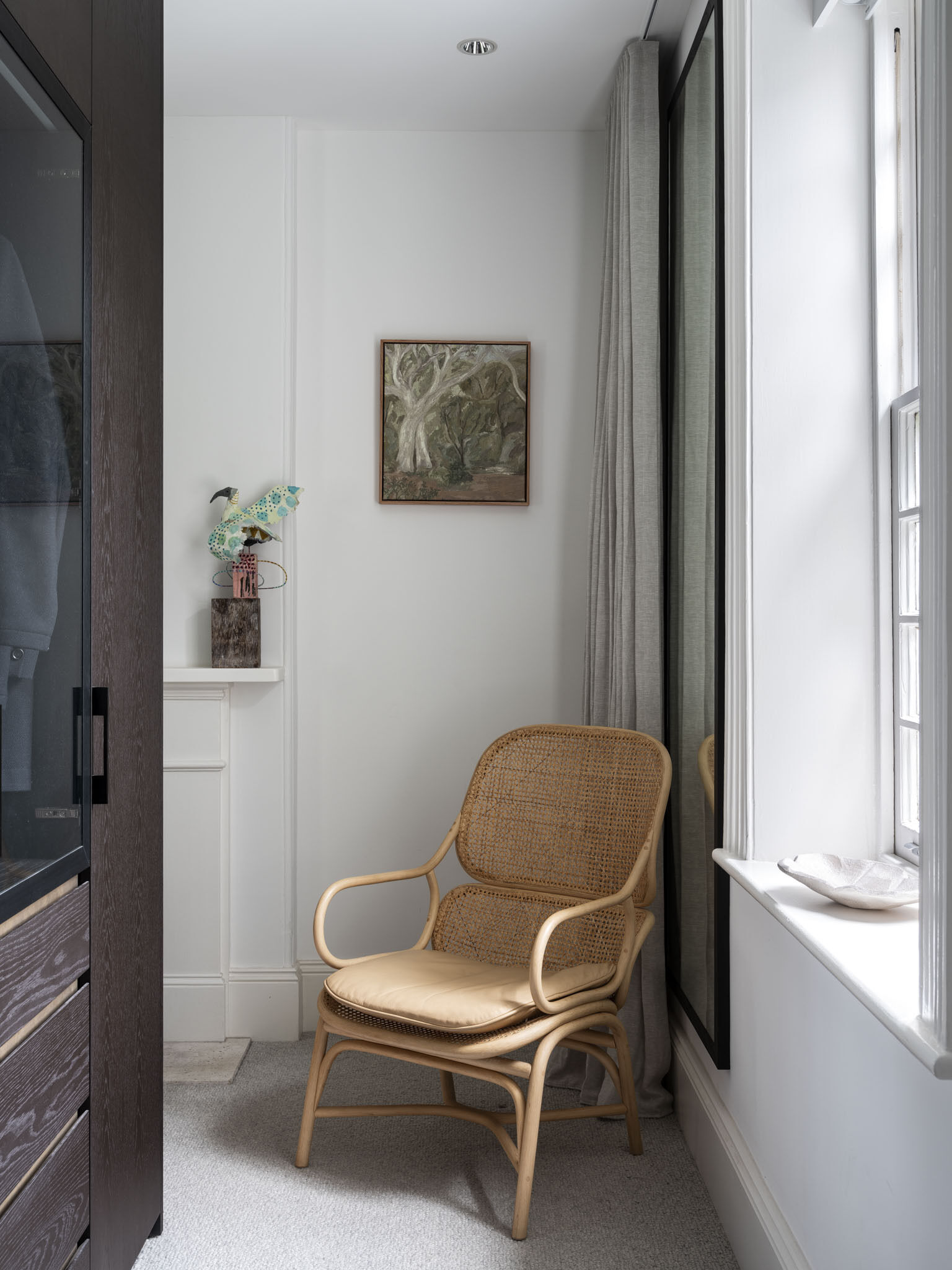 In the dressing room, the black accents complement the nearby bedroom and the bathroom.