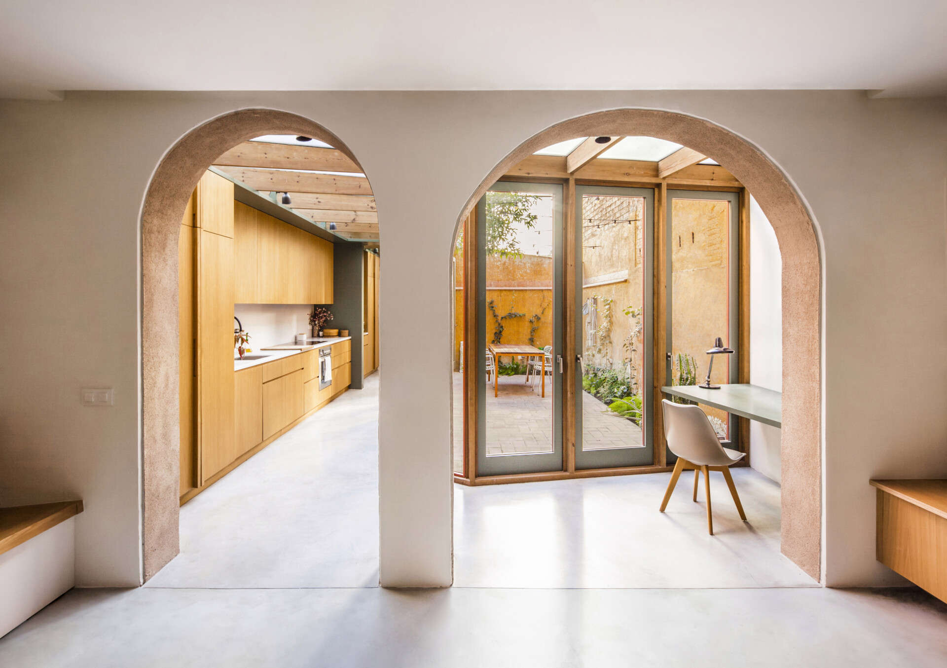 In this renovation and extension, two original arches were uncovered and left free when the facade of the extension was set back. These arches now serve as elegant transitions between the living-dining space and the gallery where the new kitchen and study are located.