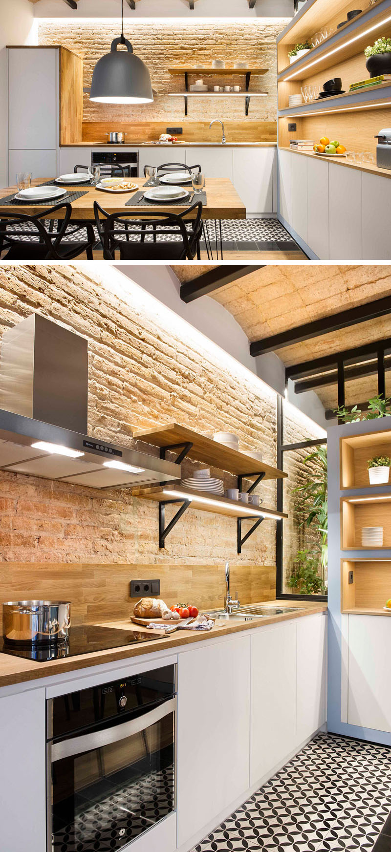 The kitchen blends warm wood countertops and backsplash with white cabinetry and stainless steel appliances. Open shelving with integrated lighting keeps the room bright while exposed brick ties it back to the apartment’s rustic heart.