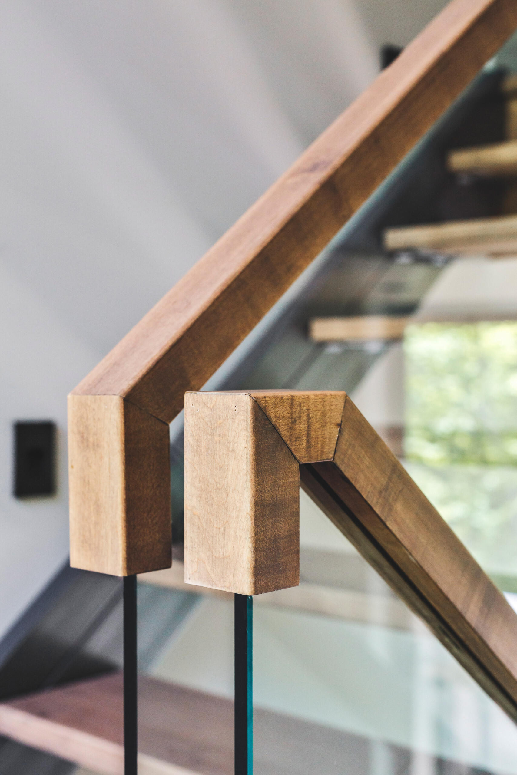 A glass-railed staircase topped with wood, is bathed in natural light connects all levels, keeping the interiors open and airy.