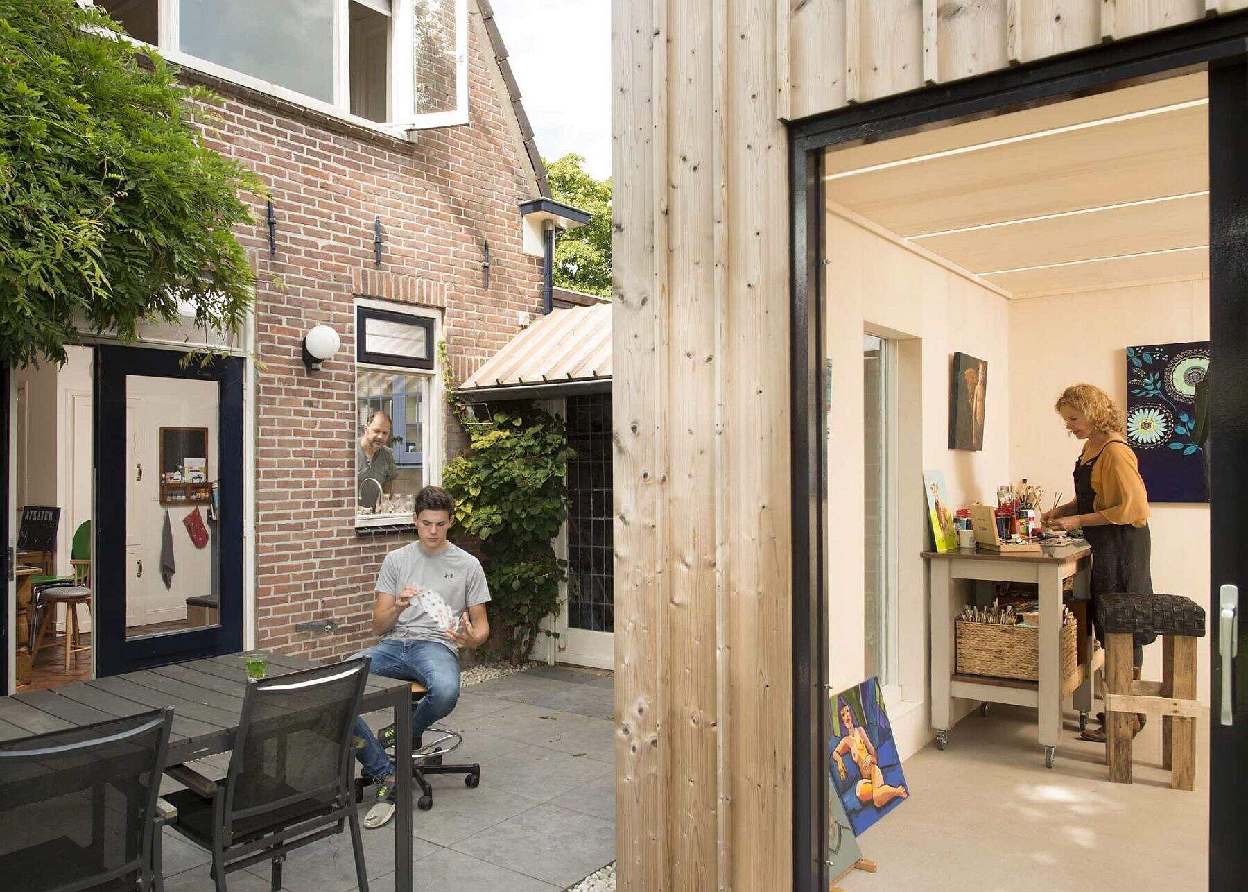 Old masonry walls and a new light wooden volume come together to create a warm, modern backyard art studio filled with natural light.