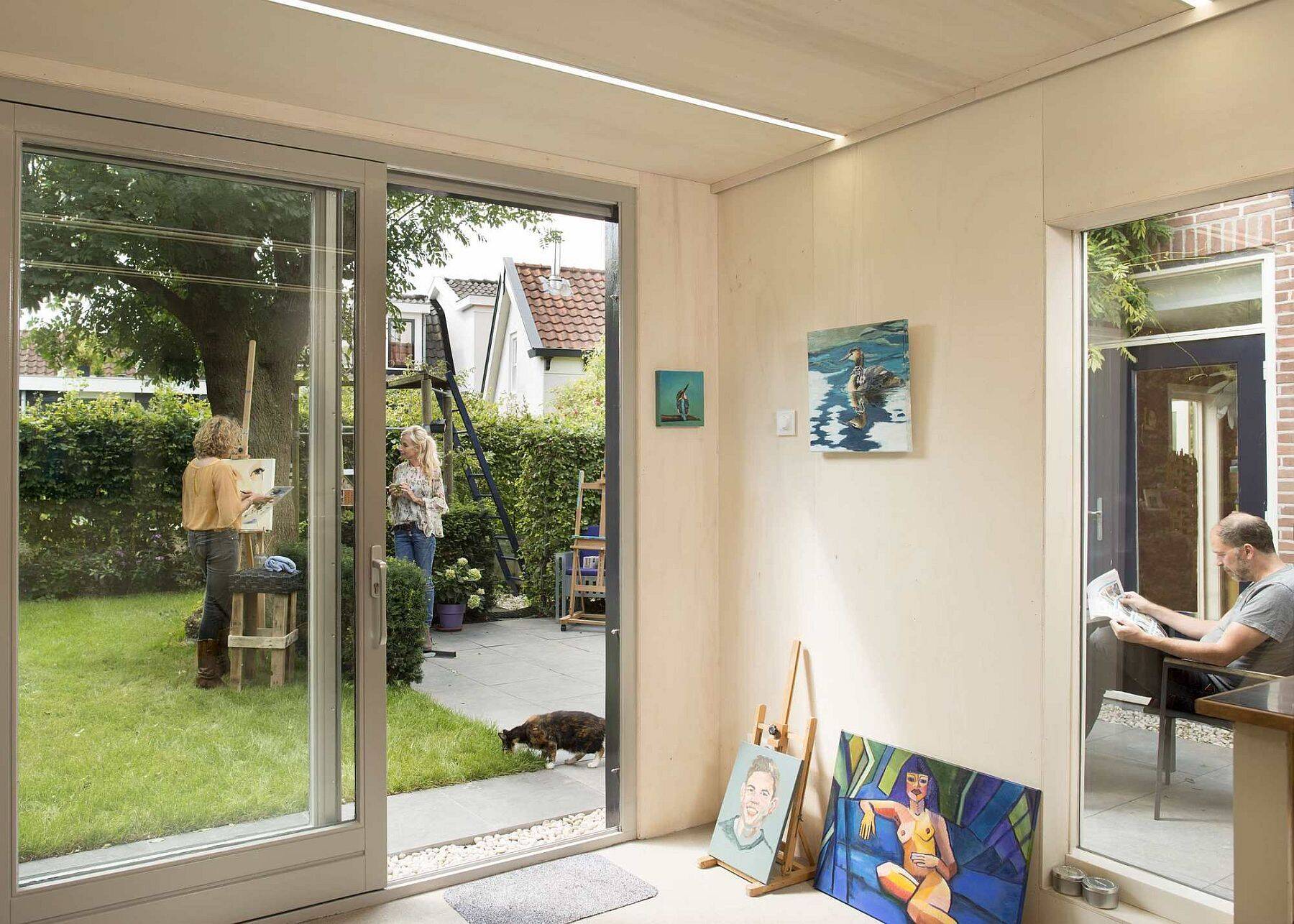 Old masonry walls and a new light wooden volume come together to create a warm, modern backyard art studio filled with natural light.