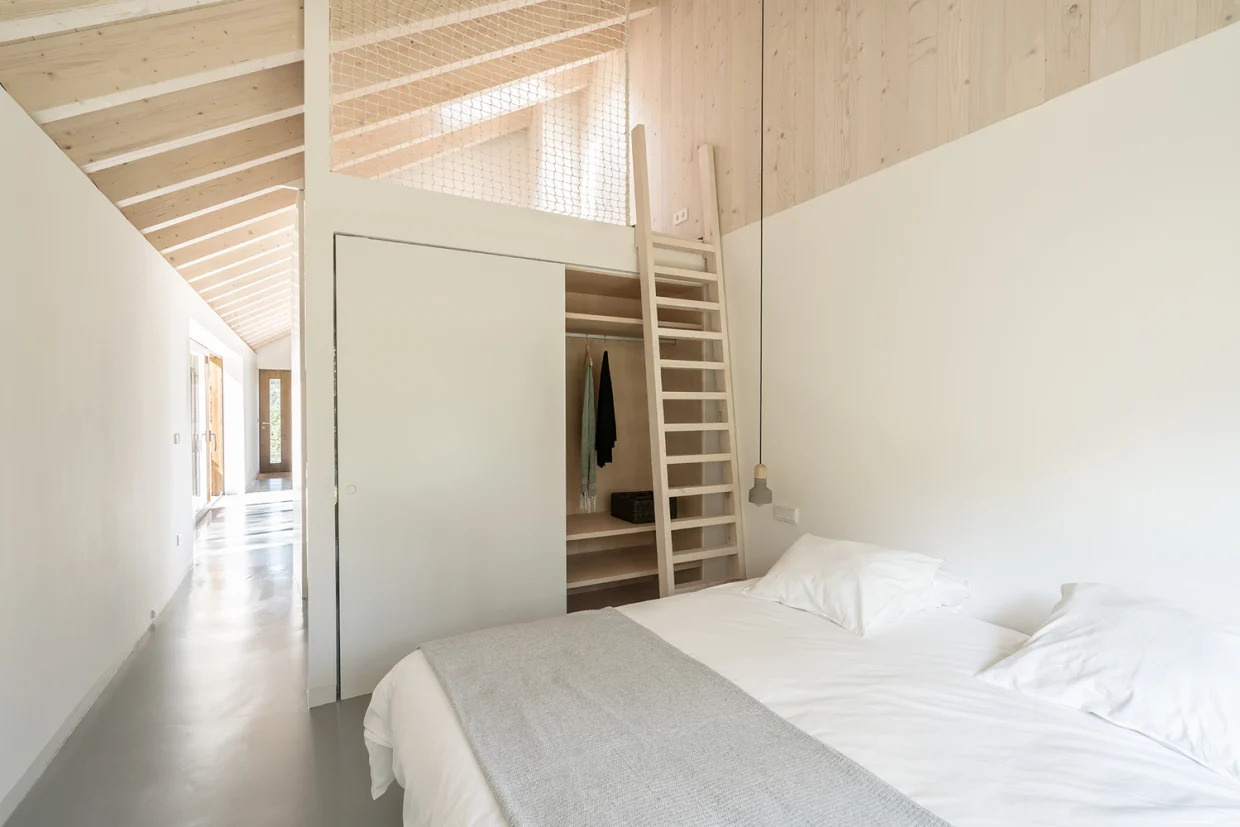 A modern yet minimal bedroom with a loft above the bathroom and closet.