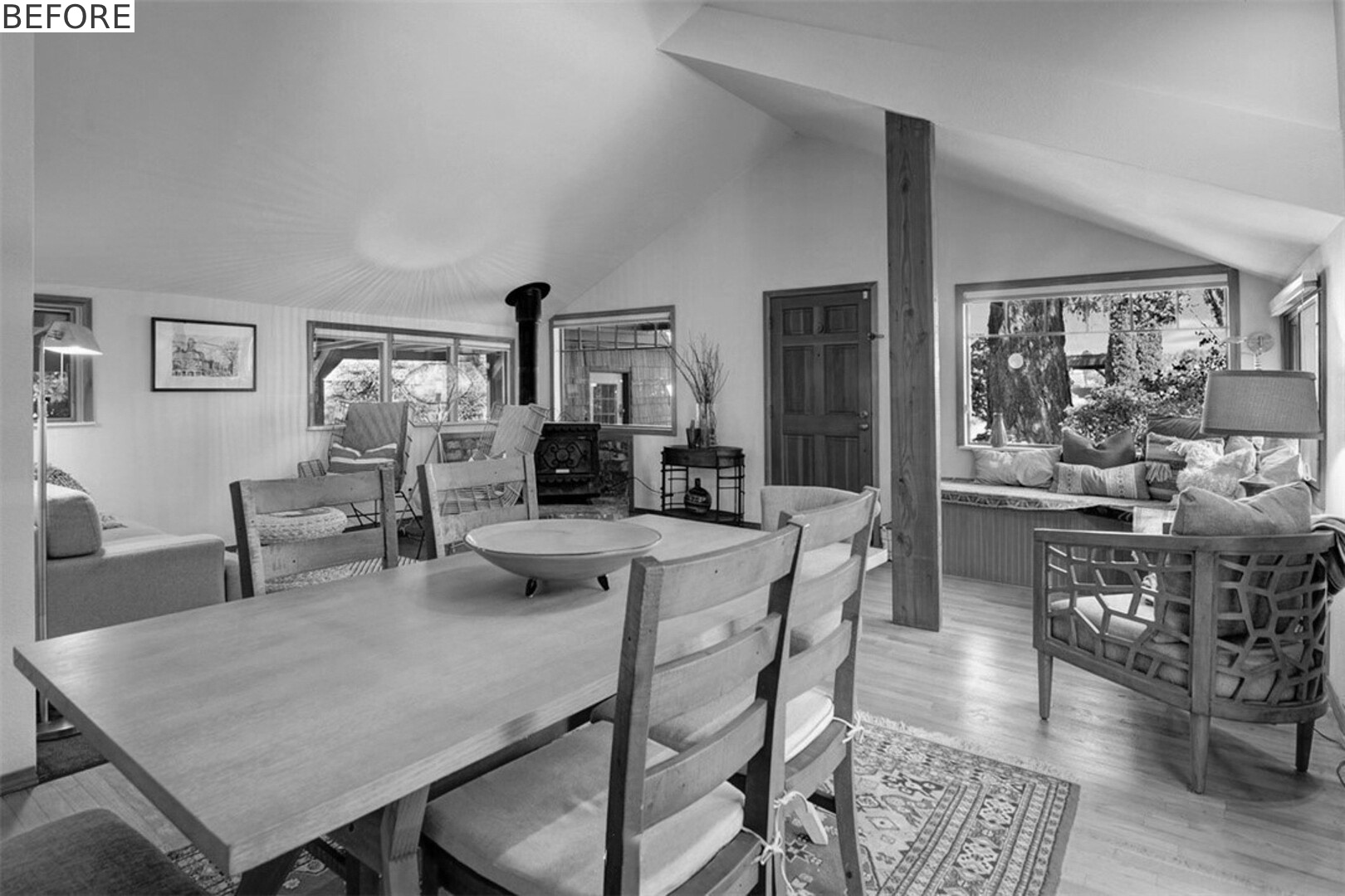 BEFORE - Open living and dining spaces now feature coral-painted steel beams and floor-to-ceiling bookshelves.
