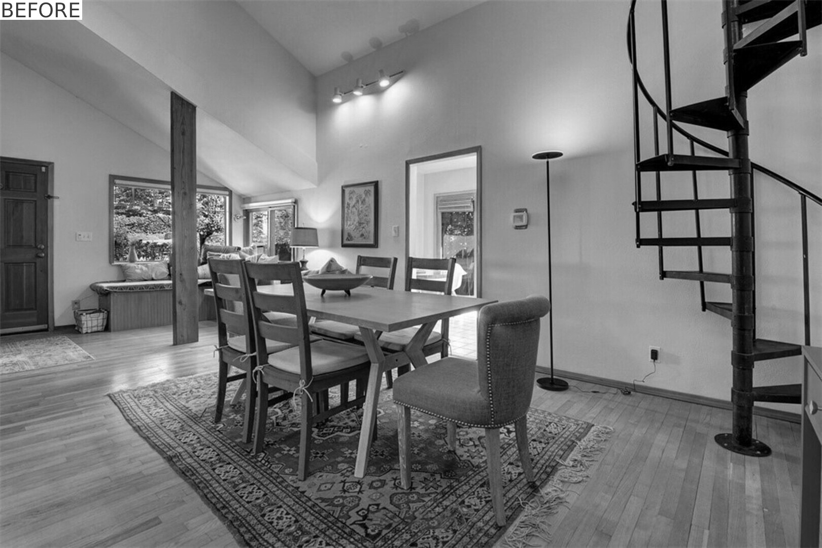 BEFORE - Open living and dining spaces now feature coral-painted steel beams and floor-to-ceiling bookshelves.