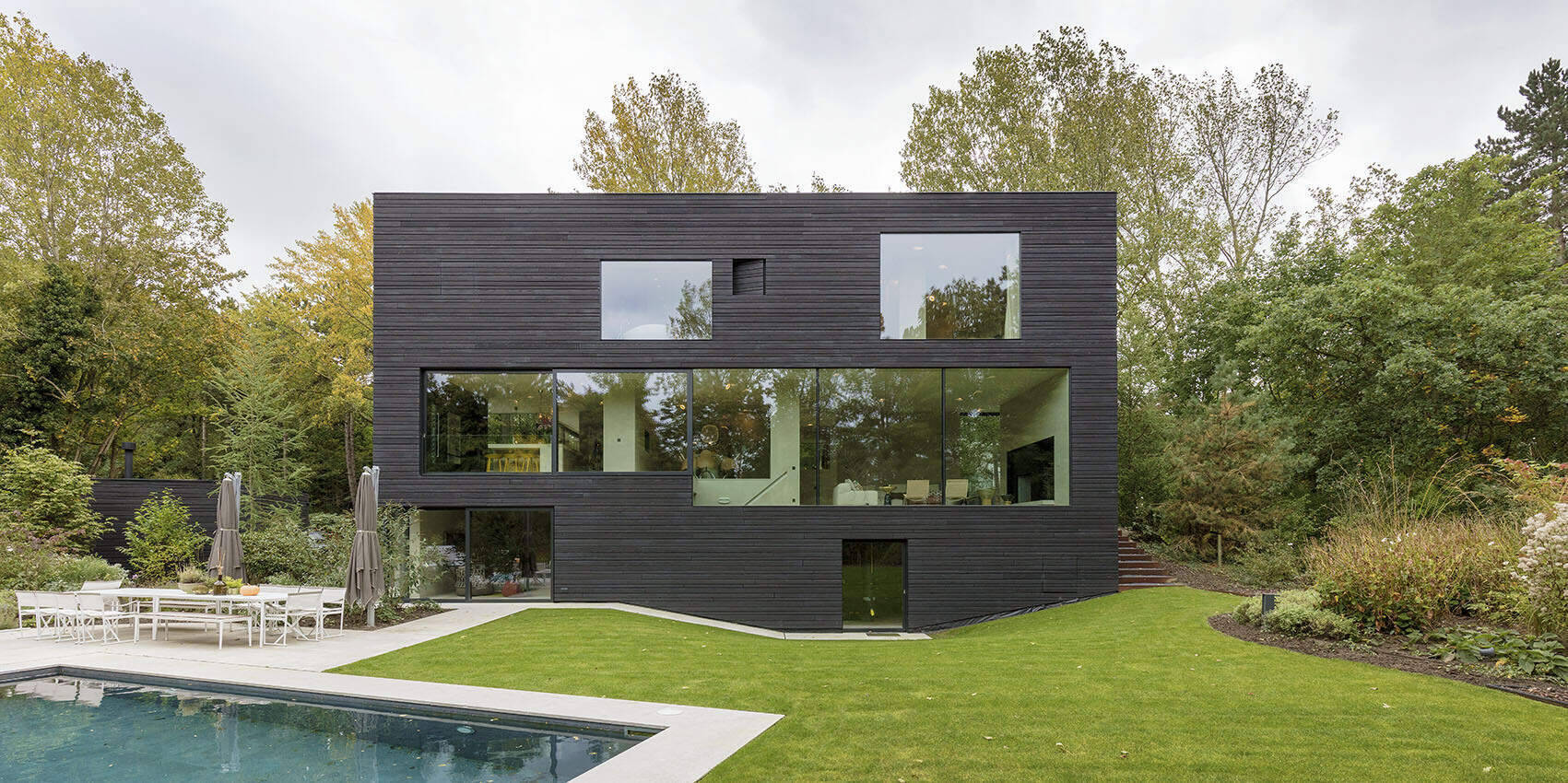 Discover how RAU Architects used charred larch wood to create a cohesive, sculptural home that blends seamlessly into the forest.