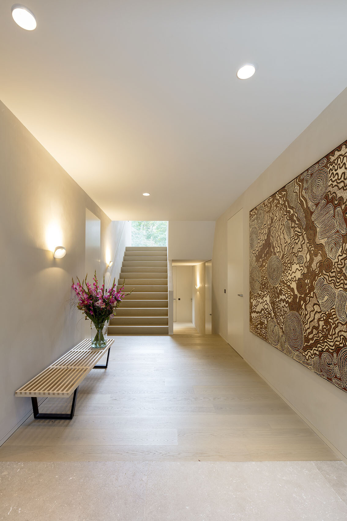 Stairs connect the home’s multiple levels, leading from the sunken ground floor to the open-plan living spaces above.