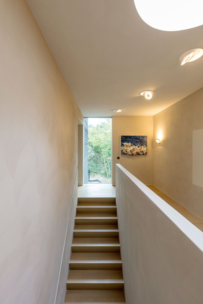 Simple stairs lead to the upper floor, where light and quiet take center stage.