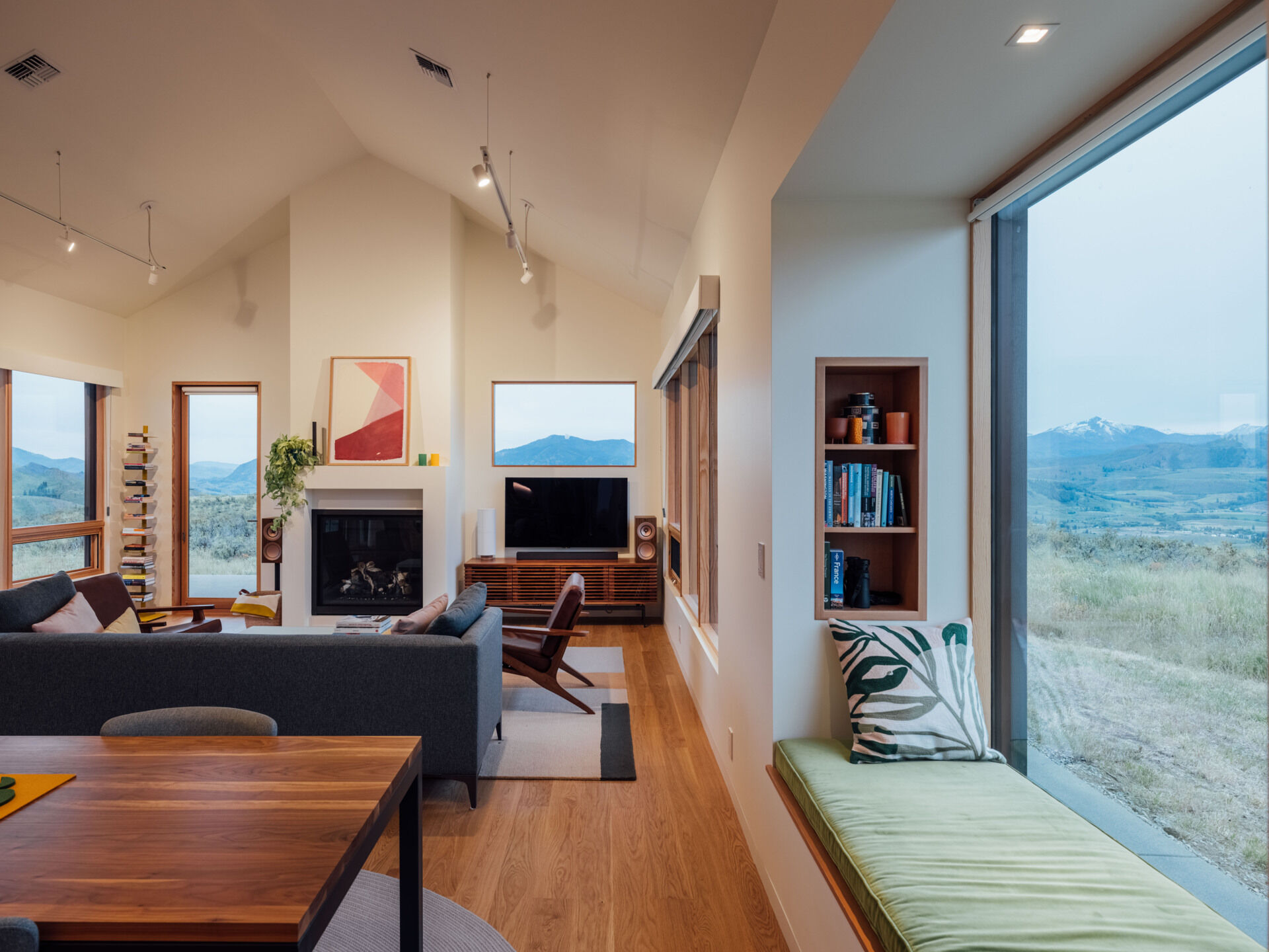 A single built-in window seat captures the heart of this Washington home. Warm wood, soft cushions, and a perfectly framed mountain view make it the most irresistible place to pause and breathe.