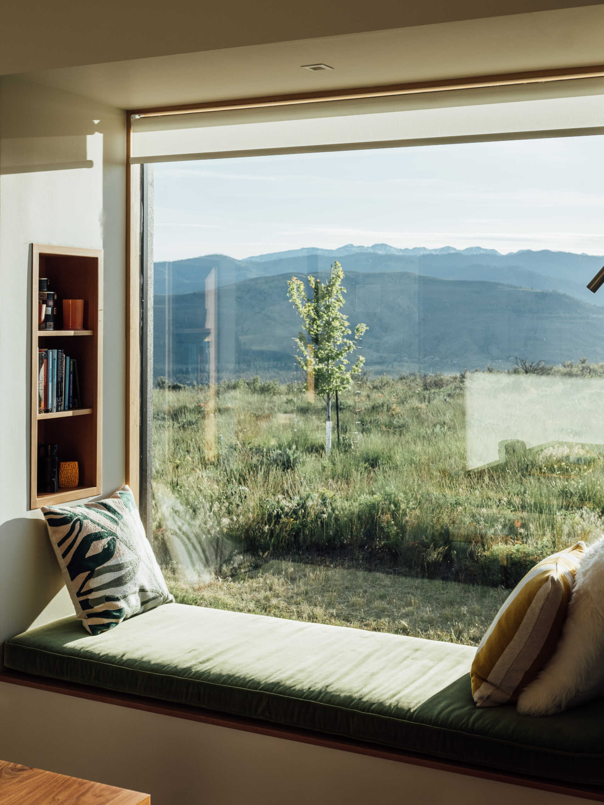 A single built-in window seat captures the heart of this Washington home. Warm wood, soft cushions, and a perfectly framed mountain view make it the most irresistible place to pause and breathe.