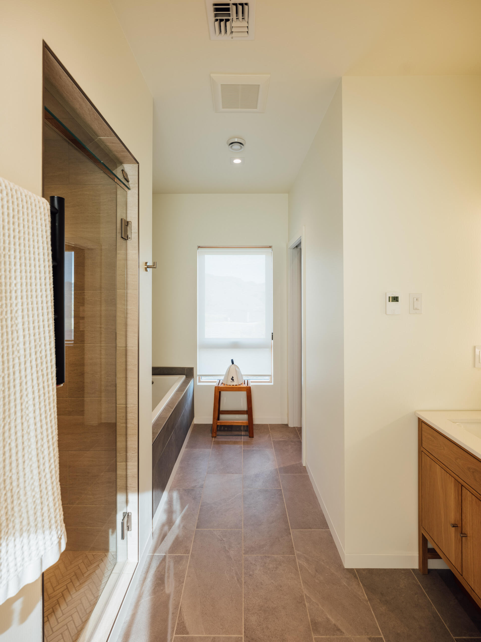 Soft light, calm surfaces, and a curated view create a sense of retreat in the ensuite. Every detail feels intentional, from the quiet materials to the way sunlight drifts through the space.